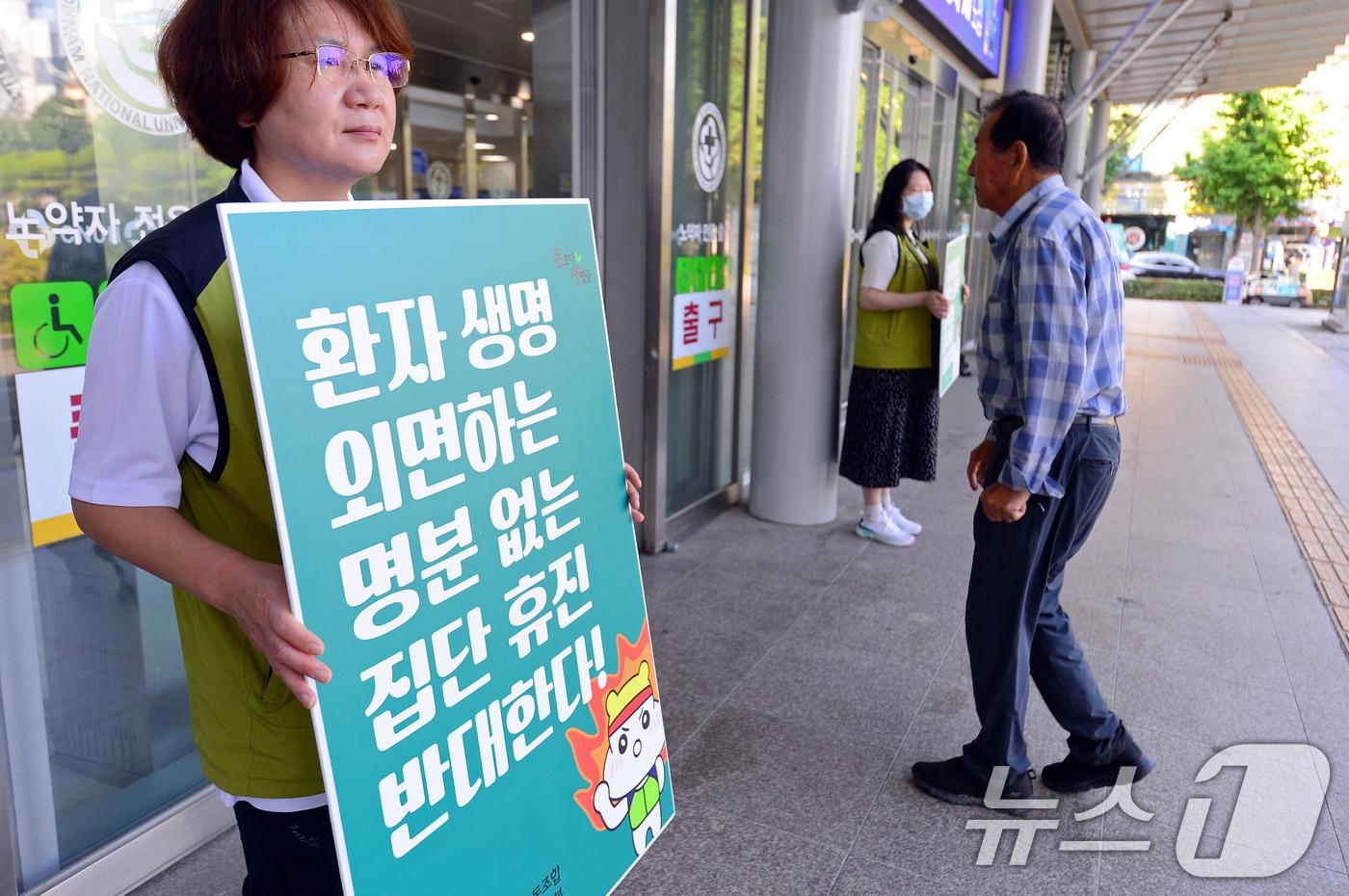 의사들이 집단 휴진을 예고한 18일 오전 광주 동구 전남대학교병원 입구에서 보건의료노조 관계자가 &#39;명분 없는 집단 휴진 반대&#39; 피켓을 들고 있다. 2024.6.18/뉴스1 ⓒ News1 이승현 기자