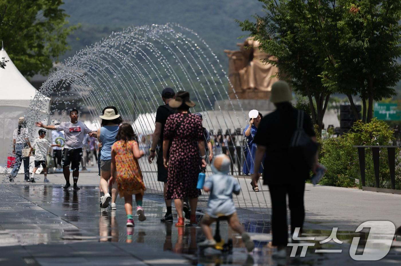 서울 낮 최고기온 32도 등 무더운 날씨를 보인 18일 광화문광장 터널분수에서 시민들이 더위를 식히고 있다. 2024.6.18/뉴스1 ⓒ News1 허경 기자