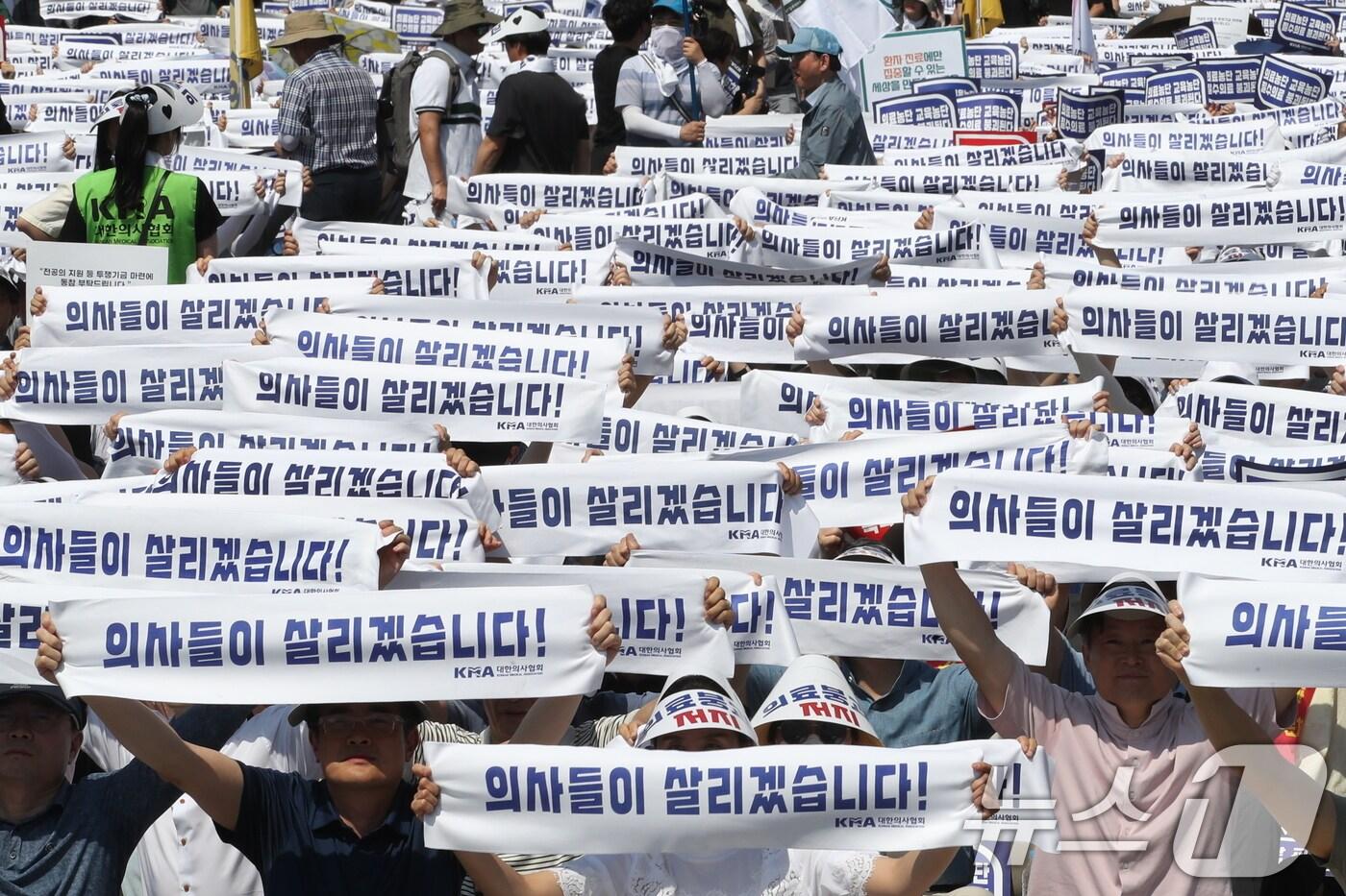 18일 서울 영등포구 여의도 환승센터 주변에서 열린 대한의사협회 전국 의사 총궐기대회에서 참석자들이 손팻말을 들고 정부에 &#39;의대 증원&#39; 철회를 촉구하고 있다. 2024.6.18/뉴스1 ⓒ News1 임세영 기자