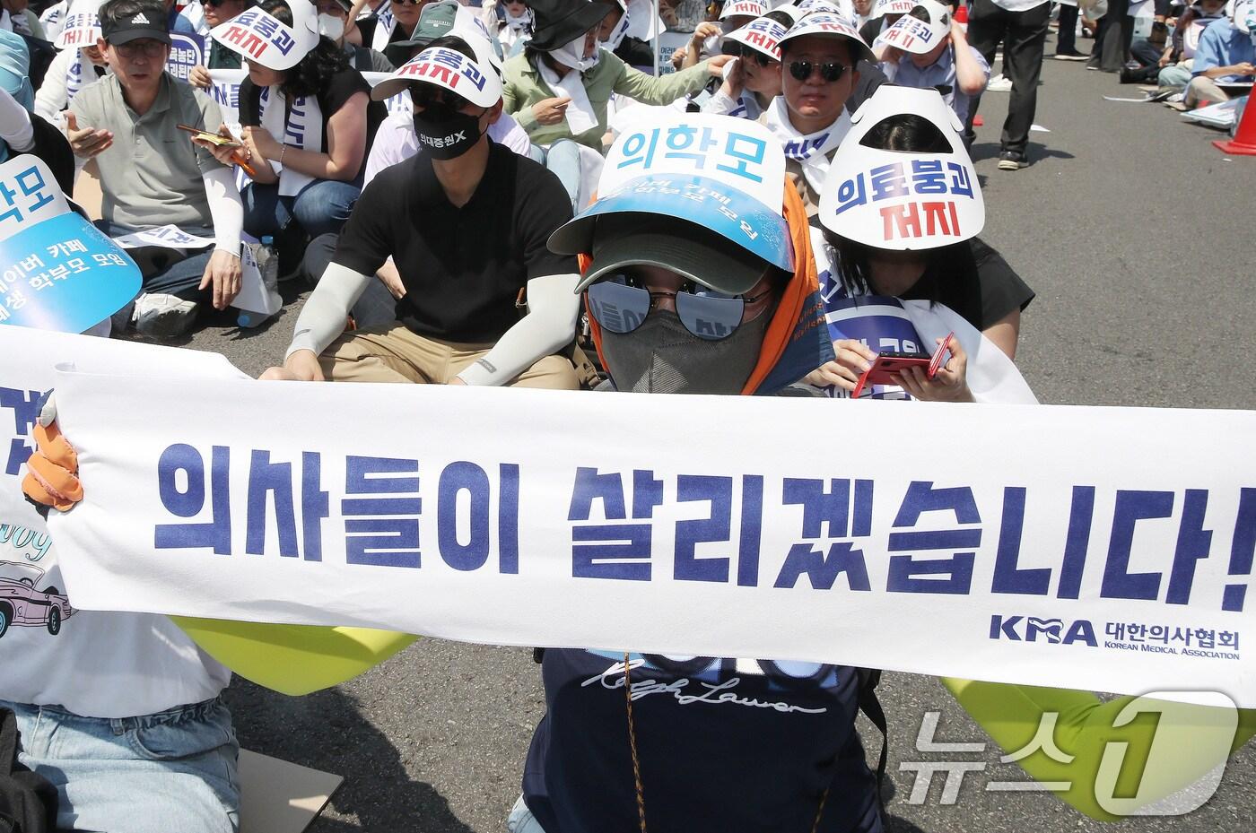 18일 서울 영등포구 여의도 환승센터 주변에서 열린 대한의사협회 전국 의사 총궐기대회에서 참석자들이 손팻말을 들고 정부의 &#39;의대 증원&#39; 철회를 촉구하고 있다. 2024.6.18/뉴스1 ⓒ News1 임세영 기자