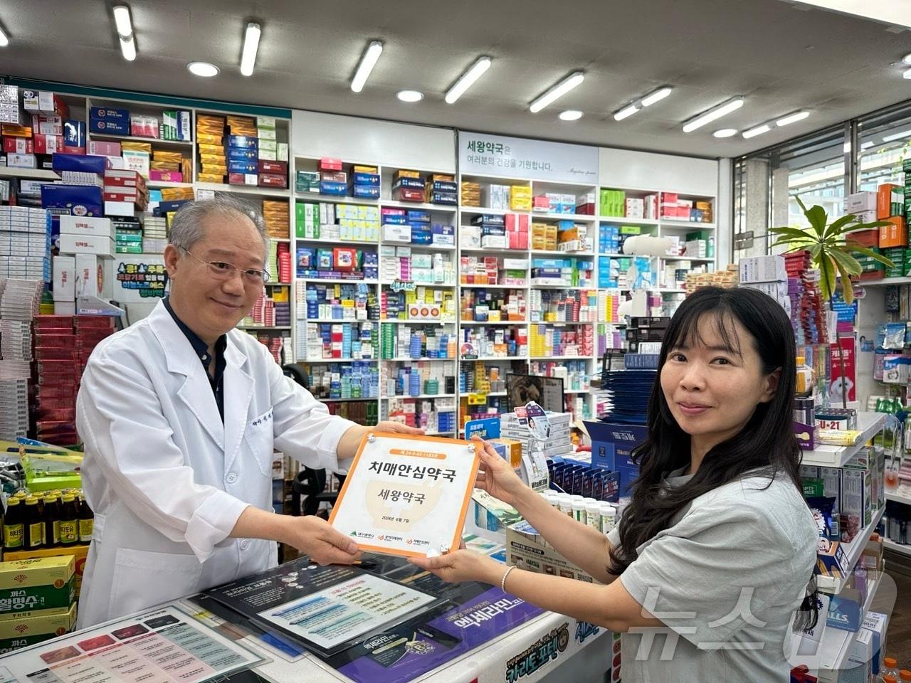 지난 12일 대구 수성구치매안심센는 신규 치매안심약국으로 지정된 세왕약국에 현판을 전달하고 기념 촬영하고 있다. &#40;대구 수성구 제공&#41;