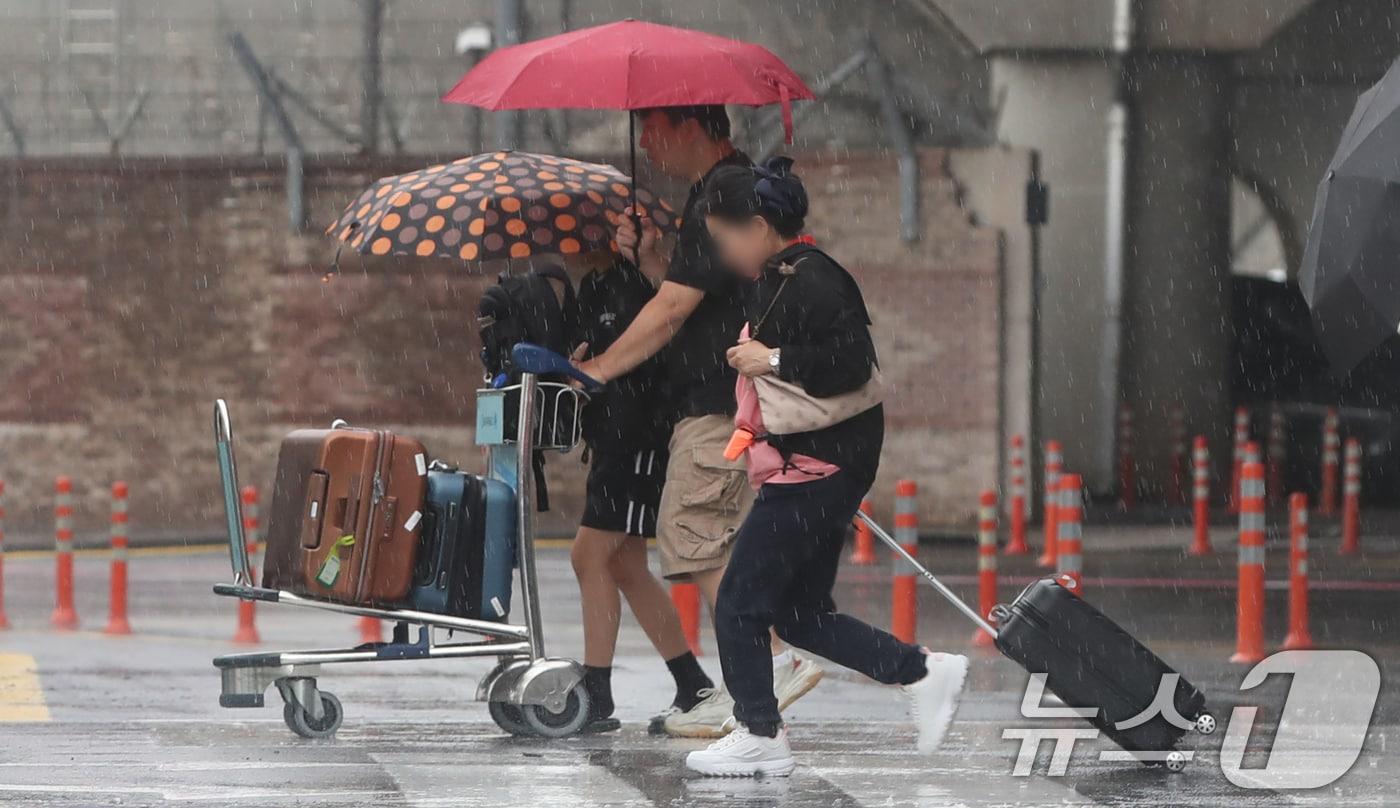 제주에 올해 첫 장맛비가 내린 20일 오전 제주국제공항에서 관광객들이 비를 피해 빠르게 이동하고 있다. 2024.6.20/뉴스1 ⓒ News1 오현지 기자