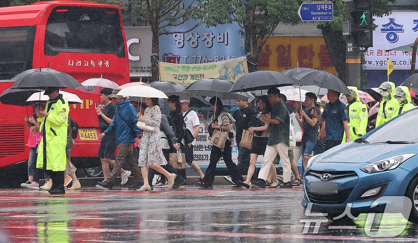 더위를 식혀주는 비가 내린 22일 오전 서울 숭례문 인근에서 시민들과 외국인 관광객들, 경찰이 우산을 쓰고 이동하고 있다, 2024.6.22/뉴스1 ⓒ News1 김진환 기자