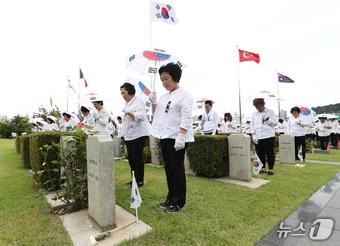 25일 부산 남구 유엔기념공원에서 열린 &#39;제74주년 6.25전쟁 참전 유엔군 전몰용사 추모제&#39;에서 태극기 우산을 쓴 참석자들이 묵념하고 있다. 2024.6.25/뉴스1 ⓒ News1 윤일지 기자