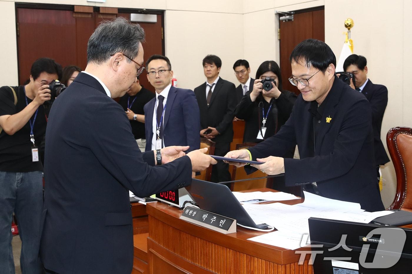 박민수 보건복지부 제2차관이 26일 오전 서울 여의도 국회 보건복지위원회 전체회의장에서 열린 의료계 비상상황 관련 청문회에 출석해 선서문을 박주민 위원장에게 전달하고 있다. 2024.6.26/뉴스1 ⓒ News1 이광호 기자