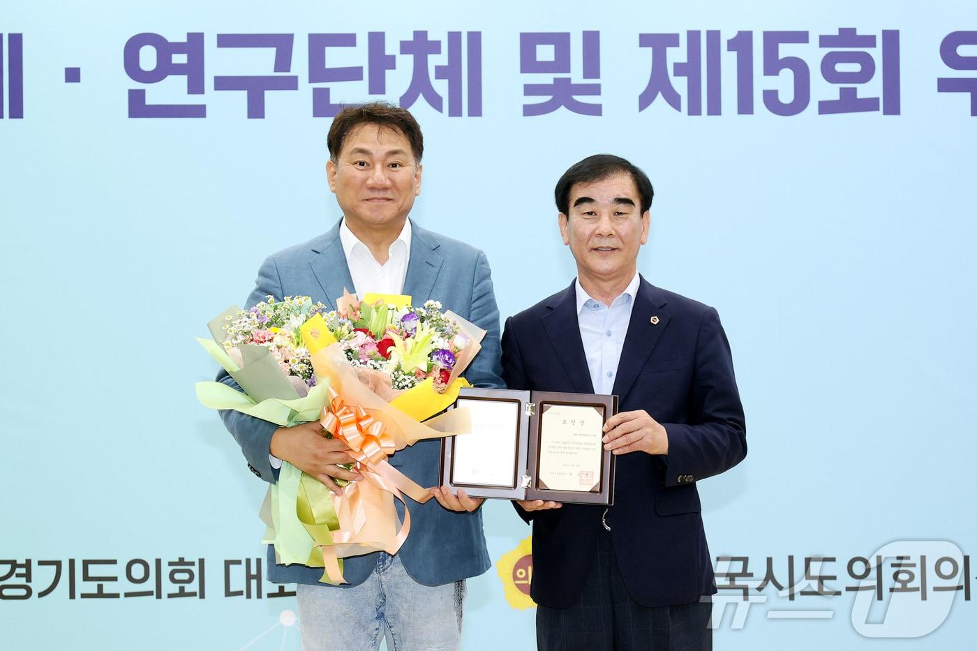 26일 경기도의회에서 열린 ‘2023년 우수연구단체 시상식’에서 최우수상을 받은 &#39;DMZ생태평화관광연구회&#39;의 회장 오준환 도의원&#40;왼쪽&#41;과 염종현 의장. &#40;오준환 도의원 제공&#41;