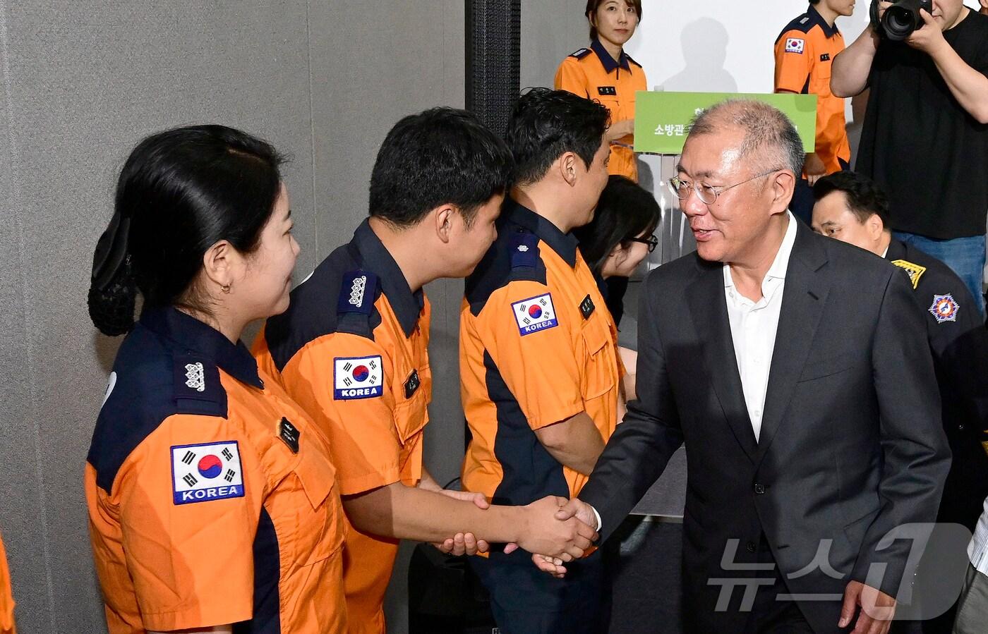 27일 제주 CFI에너지미래관에서 열린 소방관 회복지원 수소전기버스 전달행사에서 정의선 현대차그룹이 회장이 소방관들과 악수하며 인사하고 있다.  &#40;현대자동차 제공&#41; 