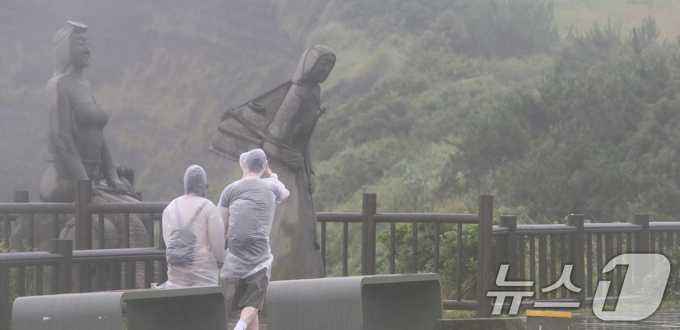 서귀포시 대정읍 송악산 둘레길에서 관광객들이 우비를 입고 이동하고 있다. 2024.6.30/뉴스1 ⓒ News1 오현지 기자