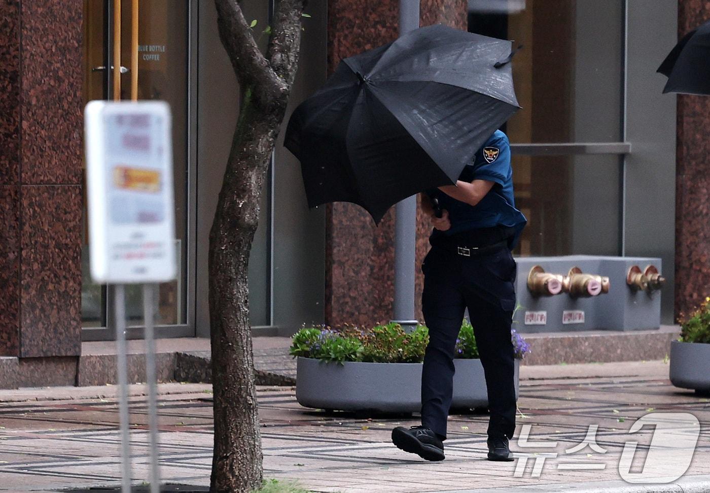 장마전선의 영향으로 전국이 흐린 가운데 30일 오전 서울 청계광장 일대에서 경찰관이 우산으로 비바람을 막으며 걷고 있다. 2024.6.30/뉴스1 ⓒ News1 구윤성 기자