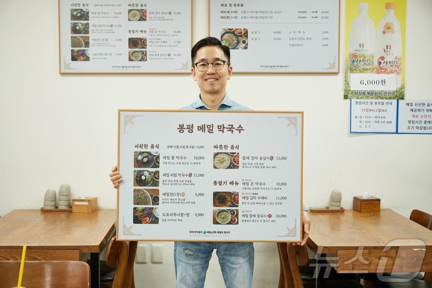 서울특별시 양천구에 위치한 ‘봉평 메밀 막국수’ 사장님이 바뀐 메뉴판을 들고 포즈를 취하고 있다.&#40;우아한형제들 제공&#41;