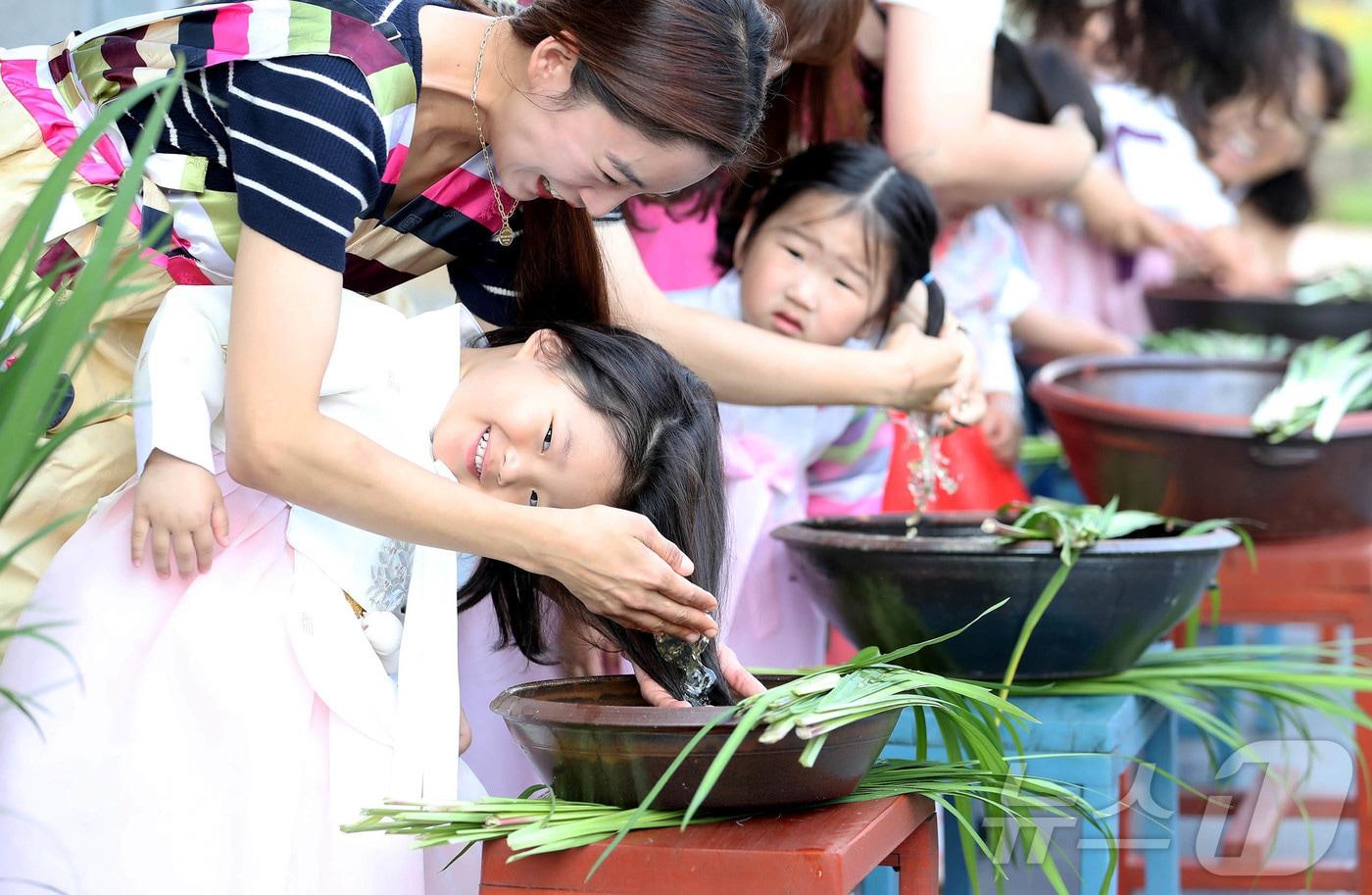 전통 명절 단오를 엿새 앞둔 4일 광주 북구 삼각동 남도향토음식박물관 야외 테라스에서 열린 전통문화 체험에 참가한 일곡키움어린이집 아이들과 학부모들이 창포물로 머리를 감고 있다. &#40;광주 북구 제공&#41;2024.6.4/뉴스1