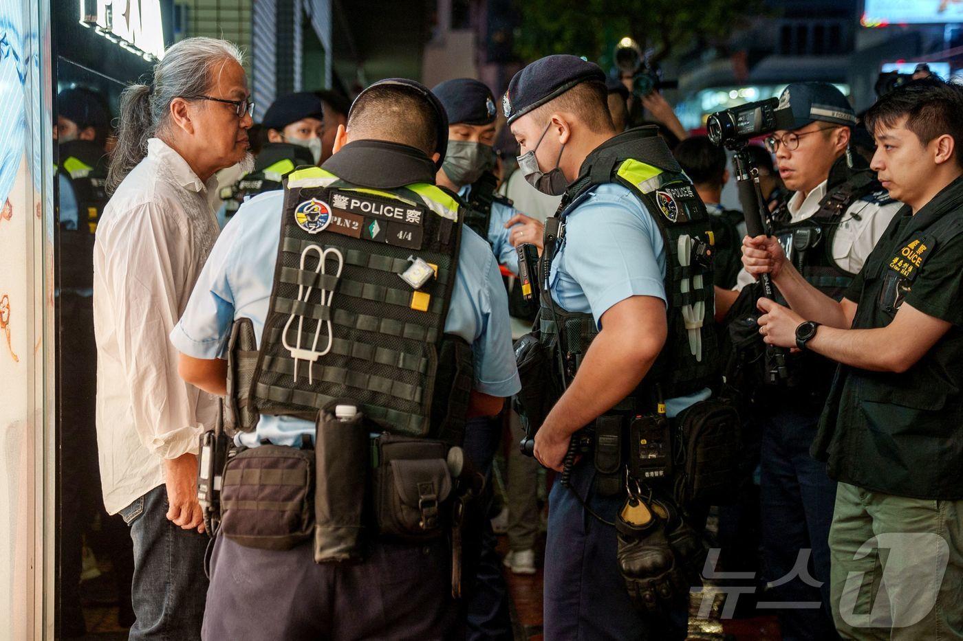 3일&#40;현지시간&#41; 홍콩 코즈웨이 베이 인근에서 경찰이 톈안먼 사태를 상징하는 손짓을 한 시민을 수색하고 있다. 2024.06.03/ ⓒ AFP=뉴스1 ⓒ News1 권진영 기자