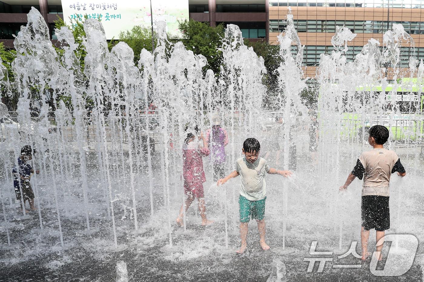 낮 기온이 30도 안팎으로 오른 9일 서울 세종대로 광화문광장 분수대를 찾은 아이들이 물줄기로 더위를 식히고 있다. 2024.6.9/뉴스1 ⓒ News1 이승배 기자