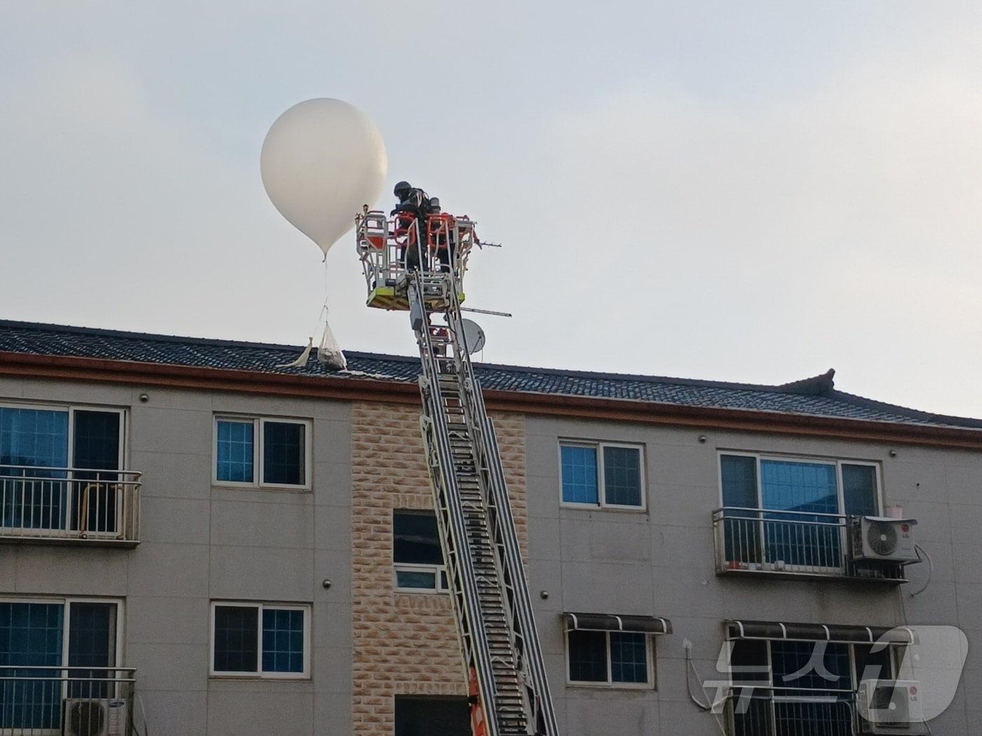 9일 오전 5시 32분쯤 인천 미추홀구 학익동 한 빌라 옥상에 떨어진 오물풍선을 소방대원이 치우고 있다.&#40;인천소방본부 제공&#41;2024.6.9/뉴스1 ⓒ News1 박소영 기자