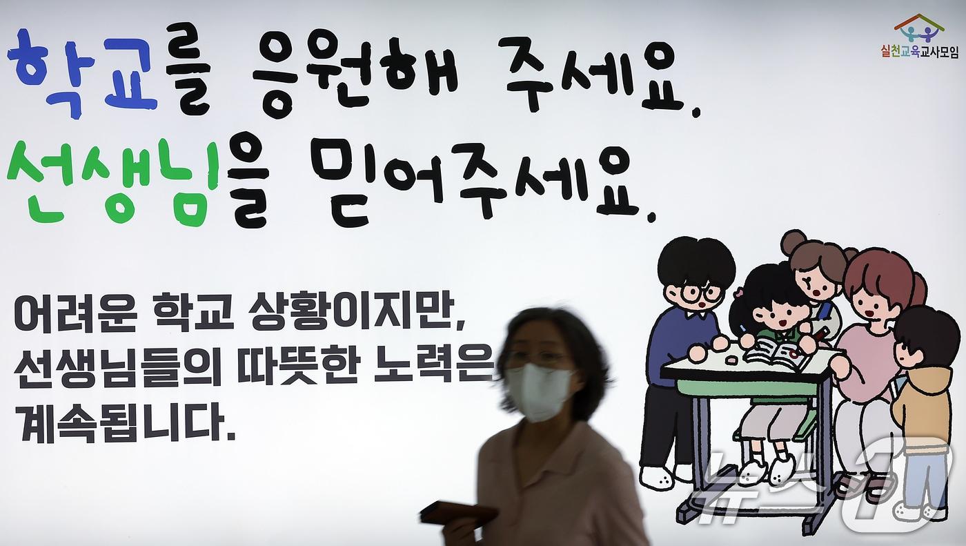 서이초 교사 순직 1주기&#40;18일&#41;를 앞둔 16일 서울 중구 봉래동 지하철 서울역에 실천교육교사모임이 모금을 통해 게시한 추모 광고 앞으로 시민이 지나고 있다. 2024.7.16/뉴스1 ⓒ News1 박정호 기자