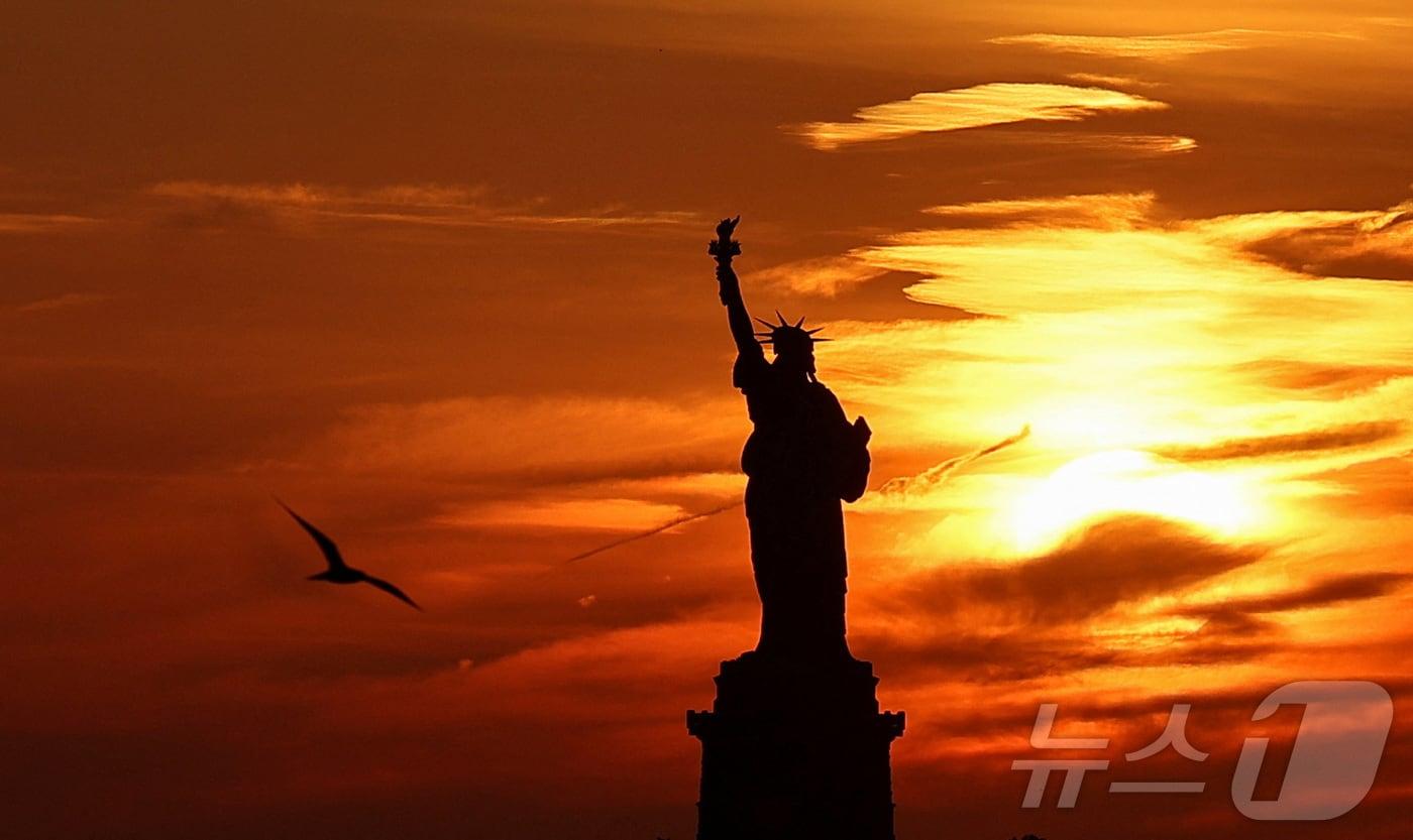 지난달 16일&#40;현지시간&#41; 미국 뉴욕 맨해튼의 명물 &#39;자유의 여신상&#40;Statue of Liberty&#41;&#39;이 일몰로 붉게 노을이 진 모습&lt;자료사진&gt;. 2024.06.16. ⓒ 로이터=뉴스1 ⓒ News1 김성식 기자