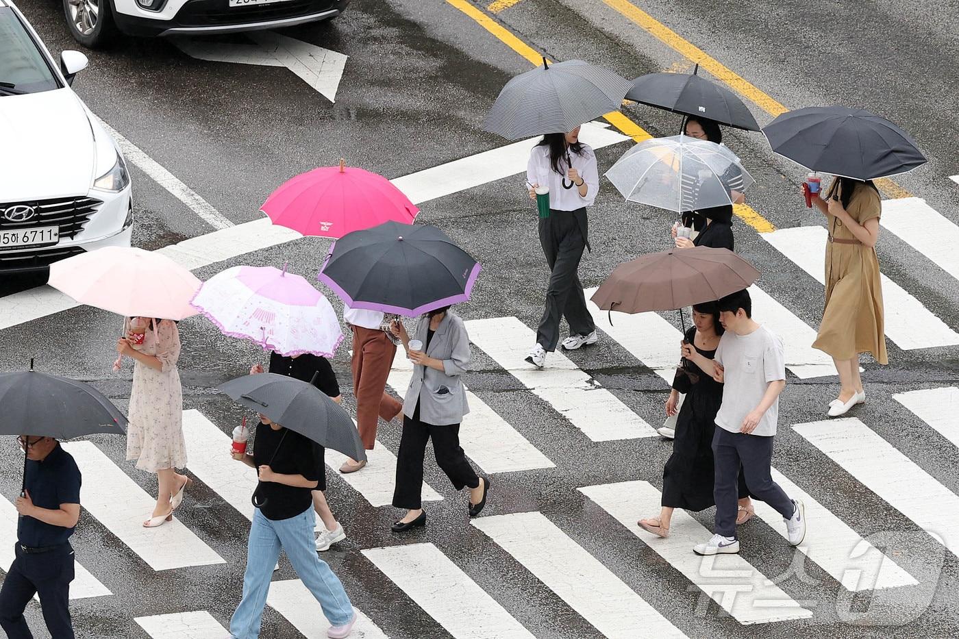 남부지방에 장맛비가 내린 19일 광주 북구청 사거리 교차로에서 우산을 쓴 구청 공직자들이 점심시간 청으로 복귀하고 있다.&#40;광주 북구 제공&#41;2024.7.19/뉴스1