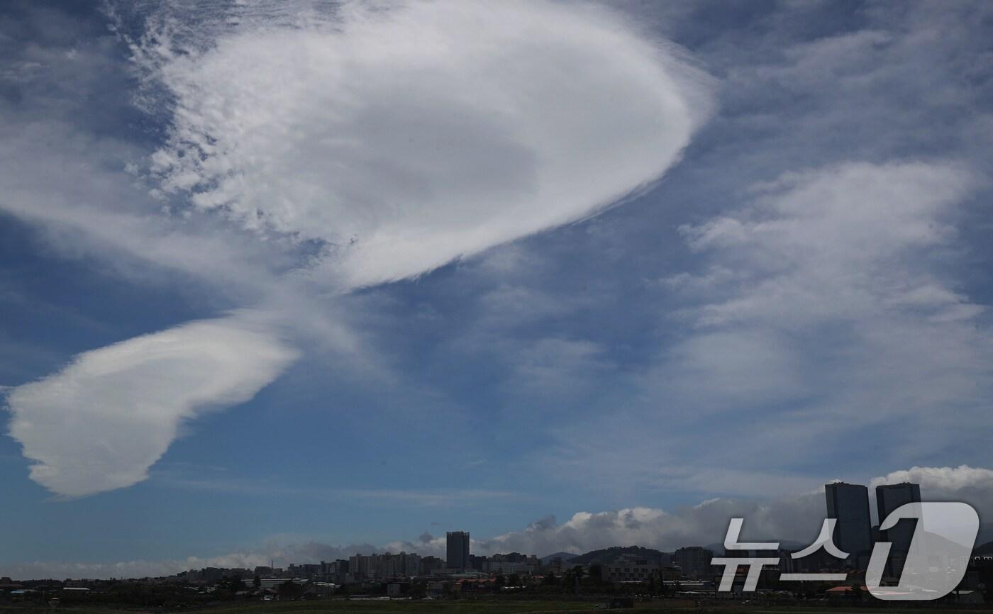 장맛비가 멈추고 제주 전역에 강풍특보가 내려진 2일 제주국제공항 상공에 렌즈형 구름이 떠 있다. 렌즈운은 날씨가 개고 덥고 습한 공기가 강한 바람을 타고 한라산을 넘어갈 때 소용돌이 형태로 만들어지는 구름이다. 2024.7.2/뉴스1