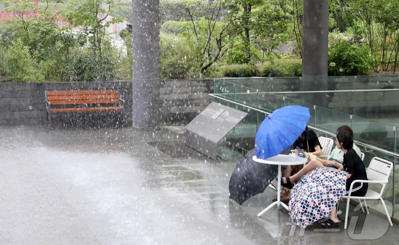 거센 장맛비가 내린 22일 오후 서울 종로구 광화문광장을 찾은 시민들이 처마 아래에서 비를 피하고 있다. 2024.7.22/뉴스1 ⓒ News1 윤주현 기자