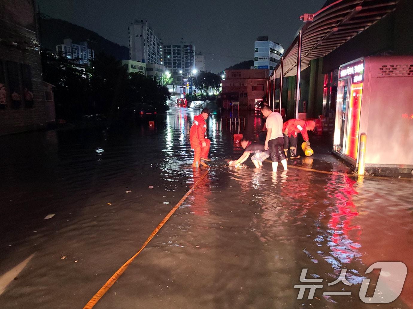 24일 오전 부산 사하구 괴정동 한 상가 건물 앞 도로가 집중호우로 인해 침수돼 소방대원들이 배수 작업을 벌이고 있다. &#40;부산소방재난본부 제공&#41; 2024.7.24/뉴스1 ⓒ News1 윤일지 기자