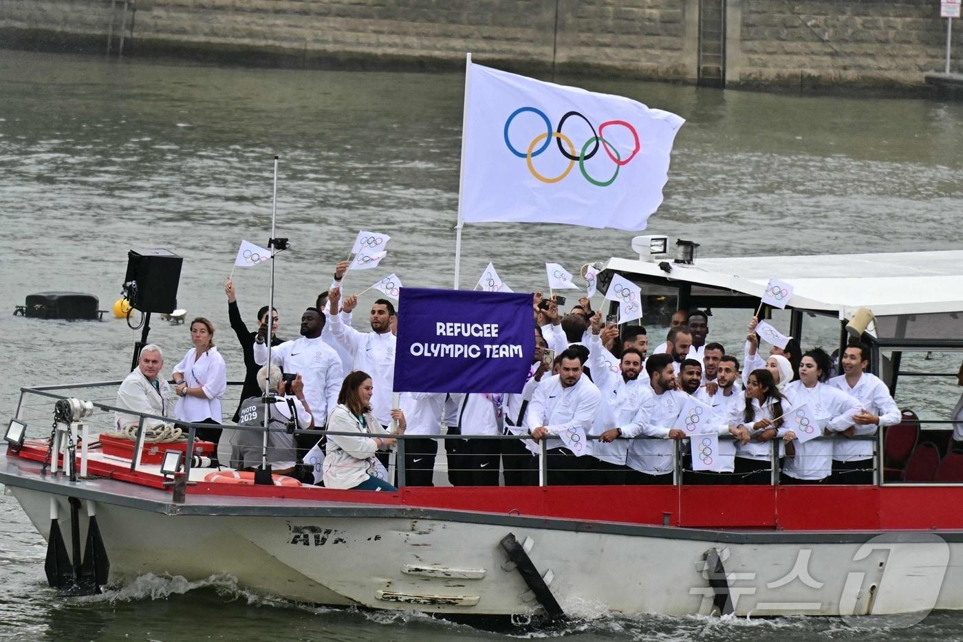 2024 파리 올림픽 개회식에 오륜기를 앞세워 입장한 난민 선수단. ⓒ AFP=뉴스1