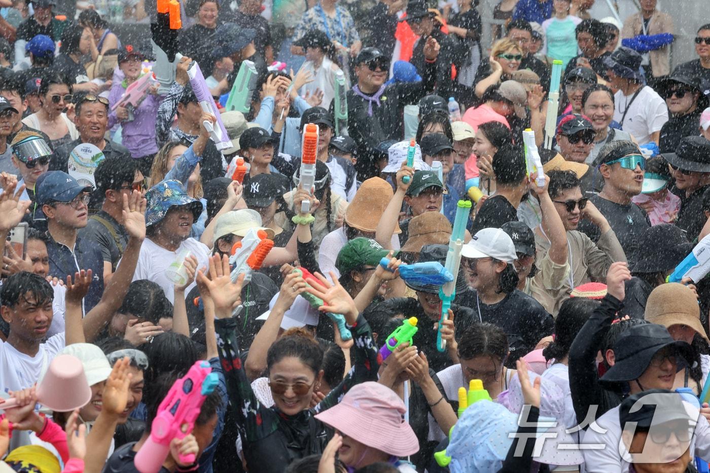 28일 국내 대표 여름축제인 &#39;정남진 장흥 물축제&#39;가 펼쳐지고 있는 장흥 탐진강 일원에서 &#39;지상최대의 물싸움&#39; 행사에 뿌려지는 물줄기사이로 관광객들이 시원함을 만끽하고 있다.  2024.7.28/뉴스1 ⓒ News1 김태성 기자