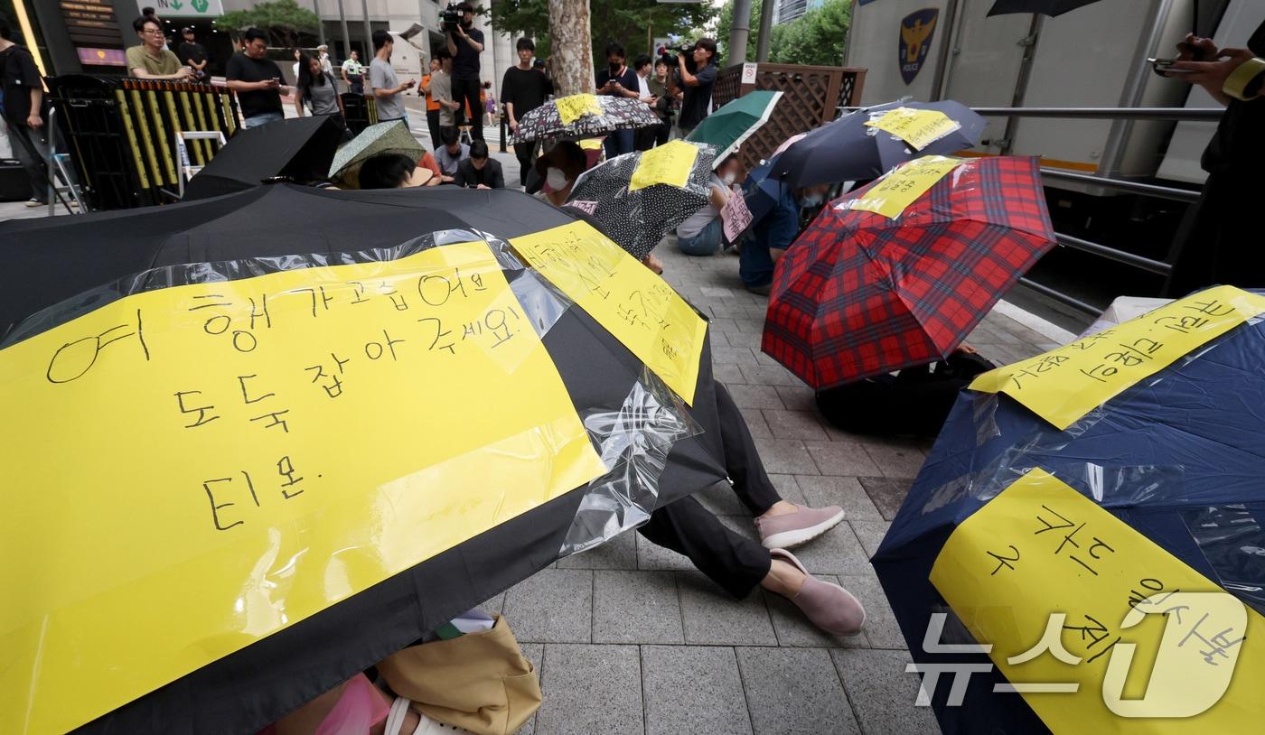 서울 강남구 큐텐 본사 앞에서 피해자들이 사태 해결을 촉구하는 문구를 붙인 우산을 쓴 채 시위하고 있다. /뉴스1 ⓒ News1 장수영 기자