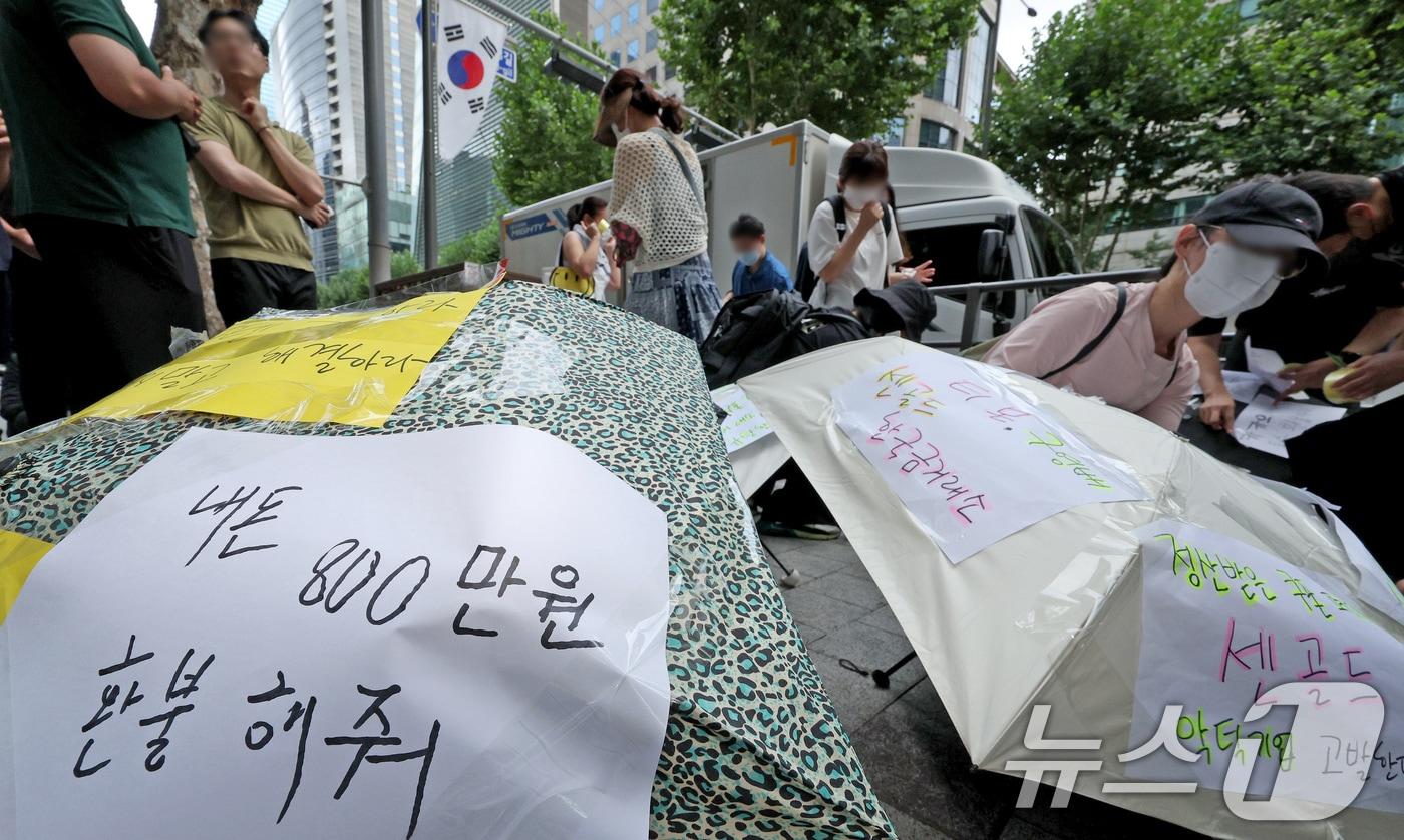 티몬과 위메프의 정산·환불 지연 사태가 지속되고 있는 28일 오후 서울 강남구 큐텐 본사 앞에서 피해자들이 사태 해결을 촉구하는 문구를 우산에 붙이며 시위를 준비하고 있다. 2024.7.28/뉴스1 ⓒ News1 장수영 기자