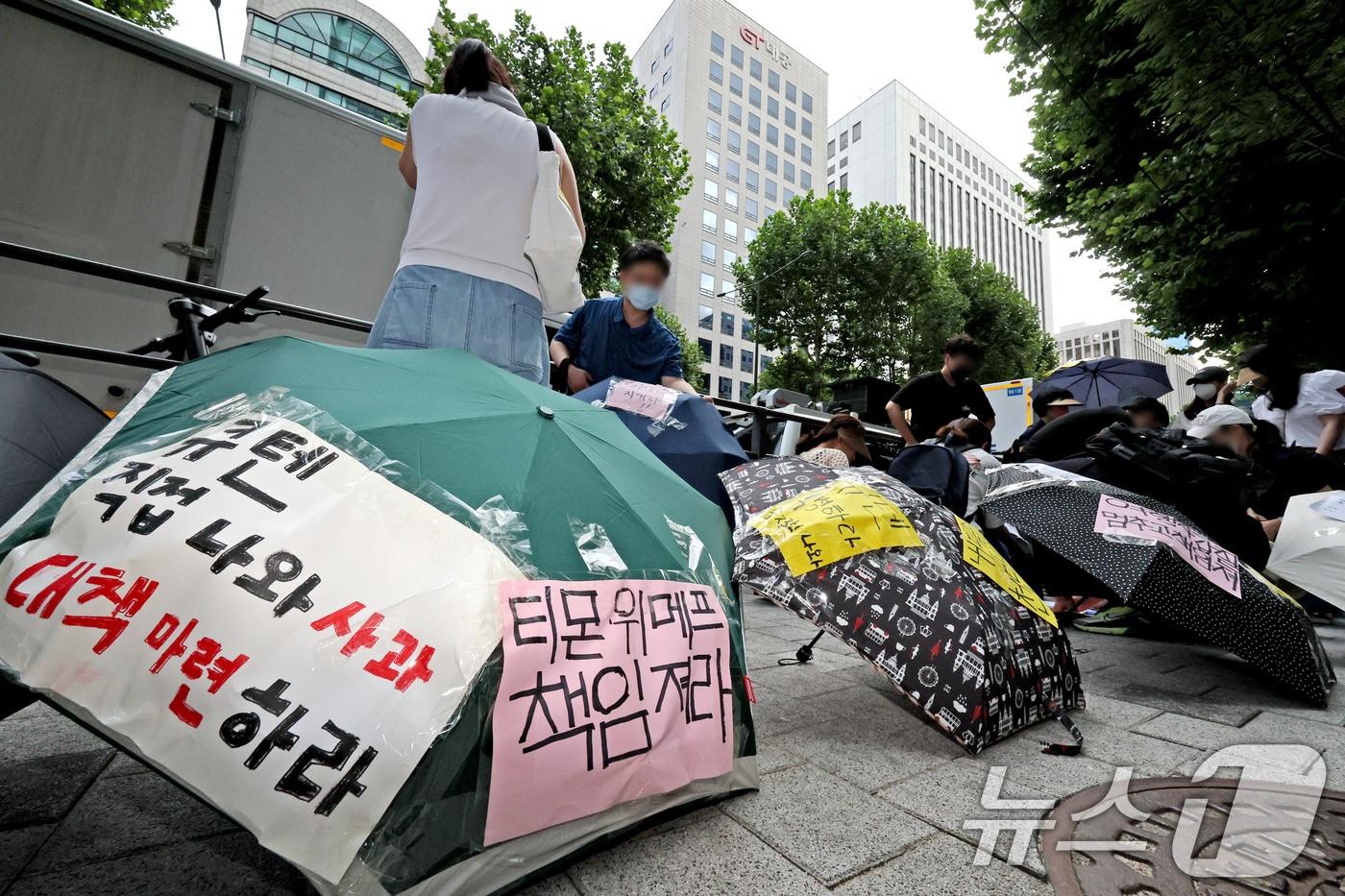 티몬과 위메프의 정산·환불 지연 사태가 지속되고 있는 28일 오후 서울 강남구 큐텐 본사 앞에서 피해자들이 사태 해결을 촉구하는 문구를 우산에 붙이며 시위를 준비하고 있다. 2024.7.28/뉴스1 ⓒ News1 장수영 기자