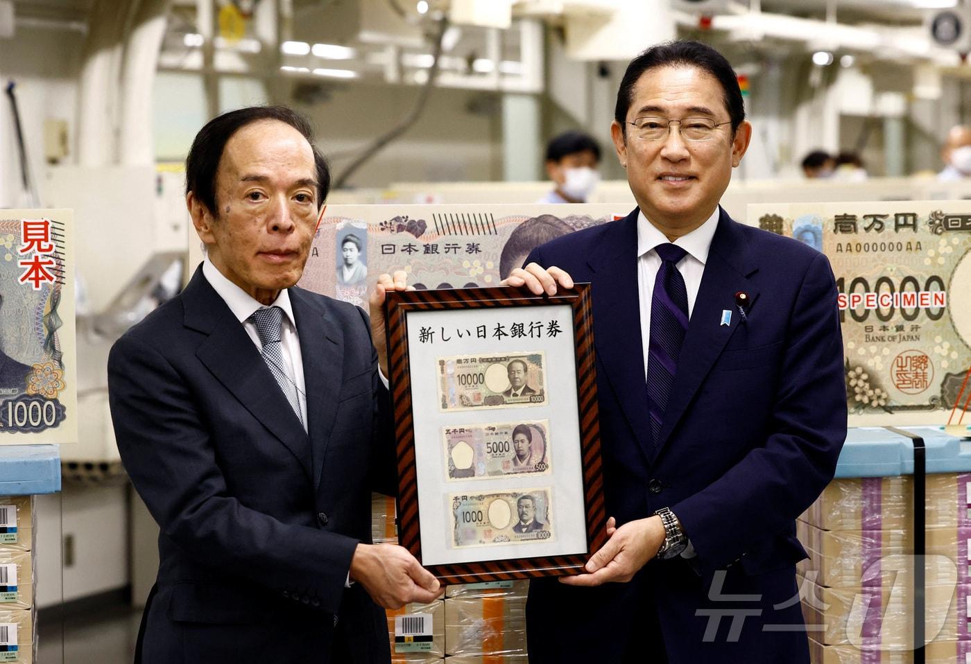 기시다 후미오&#40;오른쪽&#41; 일본 총리와 우에다 가즈오 일본은행 총리가 3일 도쿄 일본은행 본점에서 20년 만에 바뀐 △1000 엔권 △5000 엔권 △1만 엔권을 들고 기념 사진을 찍고 있다. 2024.07.03. ⓒ 로이터=뉴스1 ⓒ News1 김성식 기자