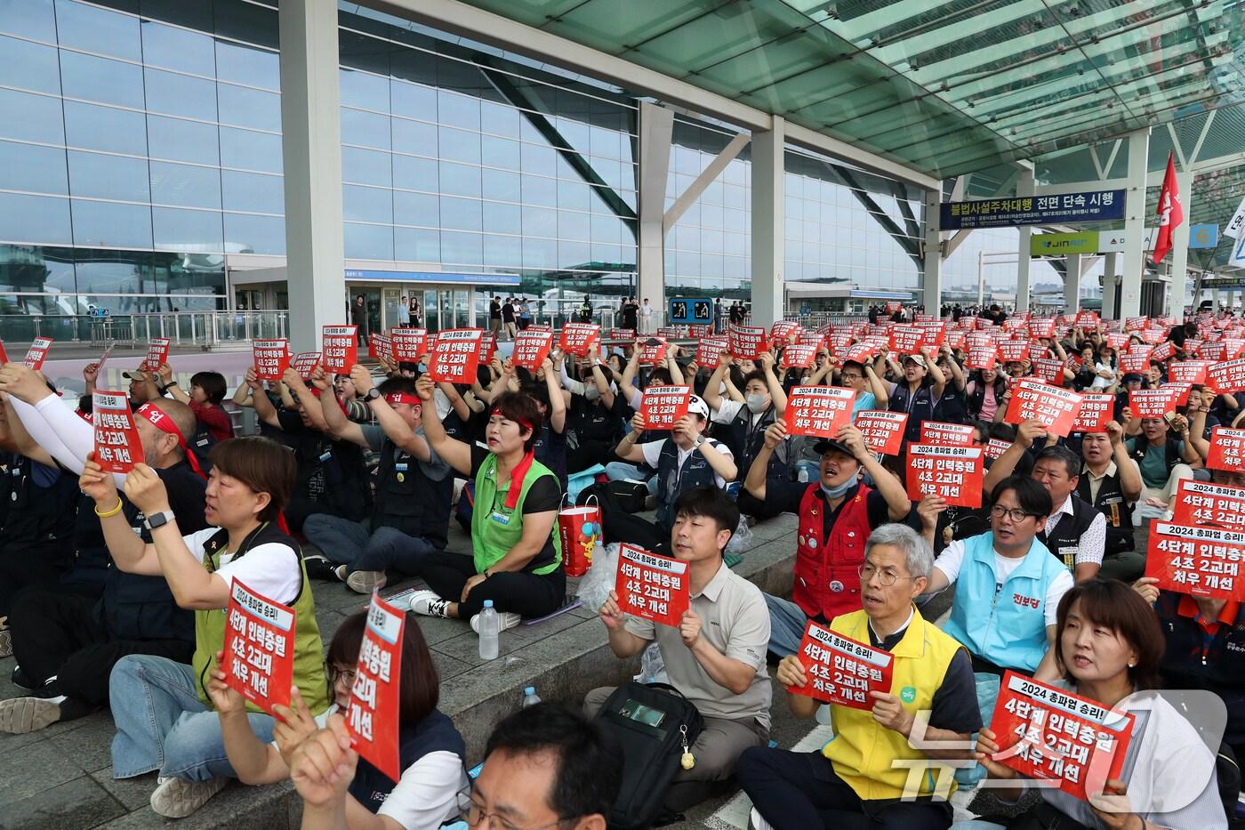 민주노총 공공운수노조 인천공항지역지부 조합원들이 30일 인천공항 2터미널 앞에서 열린 2024년 총파업 출정식에 참석해 인천공항 4단계 건설공사 준공에 따른 인력충원, 4조2교대, 처우 개선 등을 촉구하고 있다. 2024.7.30/뉴스1 ⓒ News1 이승배 기자