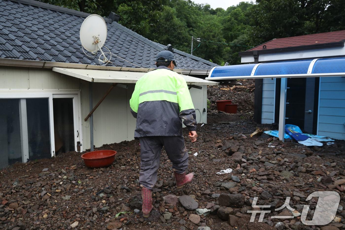 8일 오후 경북 영양군 입암면 금학리 한 주택에서 주민 이명섭&#40;73&#41; 씨가 집중호우로 뒷산에서 쏟아진 토사에 갇힌 이웃집을 살펴보고 있다. 이 씨는 &#34;새벽 3시쯤 요란한 빗소리에 잠이 깼는데 곧 정전이 됐고, 폭우가 몇 시간 동안 쉴 새 없이 쏟아졌다＂며 ＂날이 밝고 비가 잦아들어 나와봤더니 집 주변이 쑥대밭으로 변했다＂고 말했다. 2024.7.8/뉴스1 ⓒ News1 공정식 기자