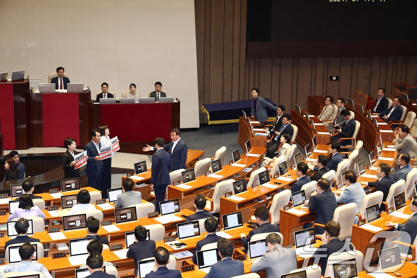 전종덕&#40;단상 앞 왼쪽부터&#41;, 윤종오, 정혜경 진보당 의원이 1일 오후 서울 여의도 국회에서 제416회국회&#40;임시회&#41; 제2차 본회의에 앞서 국민의힘 의원들을 향해 &#39;대통령은 거부말라&#39;, &#39;국민의힘은 동참하라&#39;라고 적힌 손팻말을 들고 있다. 2024.8.1/뉴스1 ⓒ News1 김민지 기자