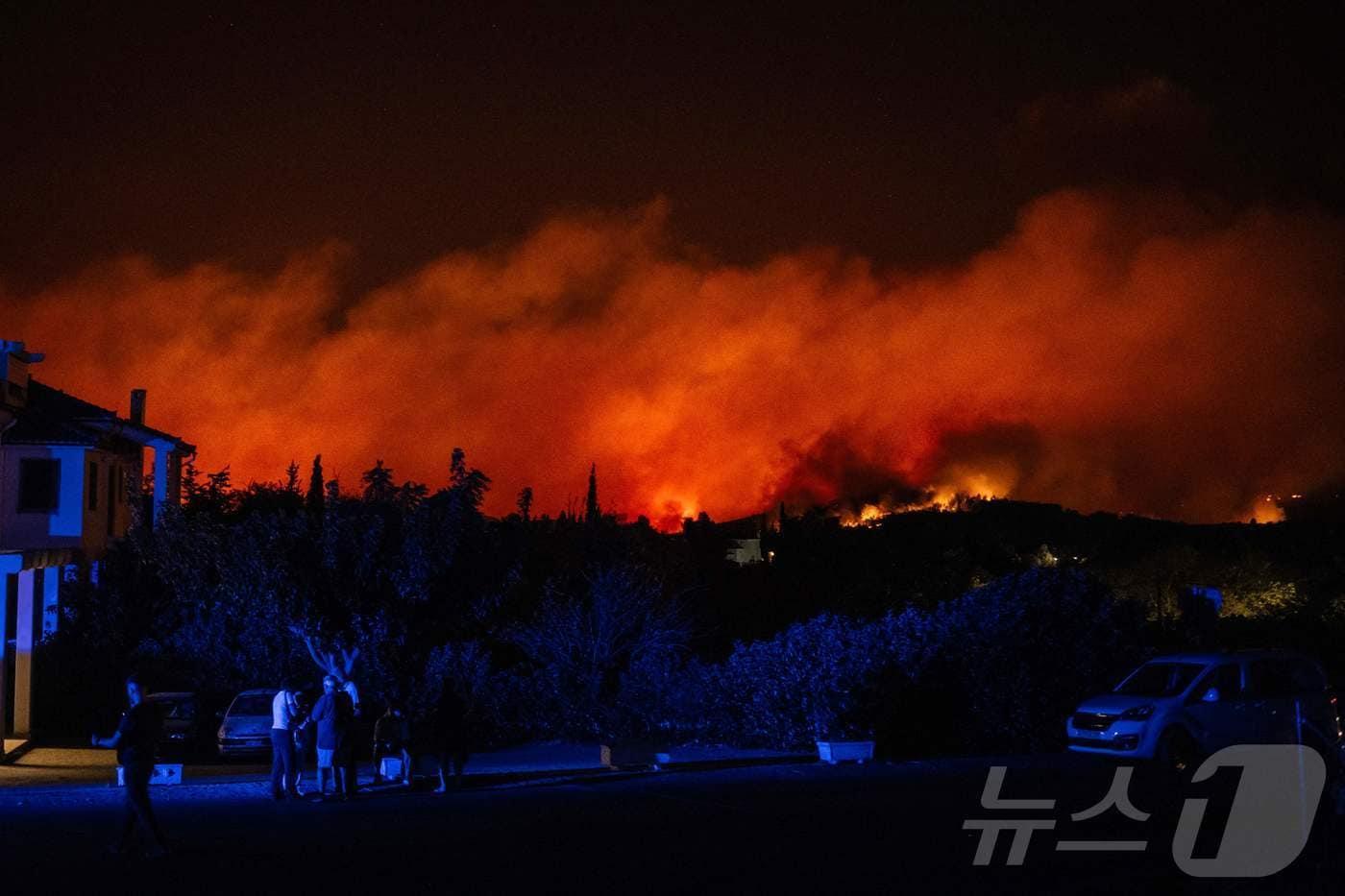 11일&#40;현지시간&#41; 아테네 북쪽 바르나바스의 한 산비탈에서 산불이 타오르고 있는 가운데 지역 주민들이 길을 따라 서 있다. 24.08.11 ⓒ AFP=뉴스1 ⓒ News1 김예슬 기자