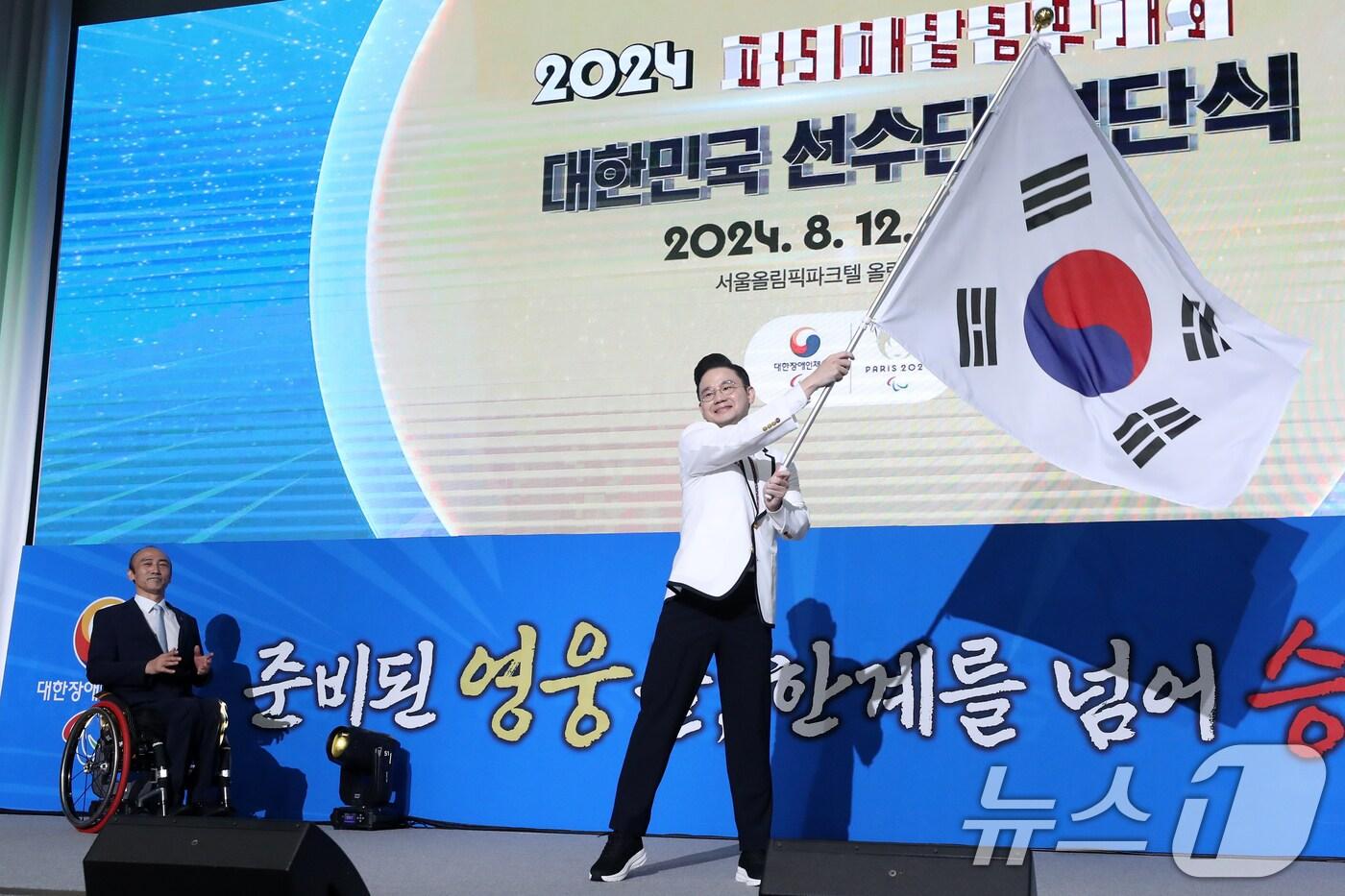 배동현 파리 패럴림픽 선수단장이 12일 오후 서울 송파구 올림픽파크텔에서 열린 &#39;2024 파리 패럴림픽 대한민국 선수단 결단식&#39;에서 태극기를 흔들고 있다. 2024.8.12/뉴스1 ⓒ News1 이승배 기자