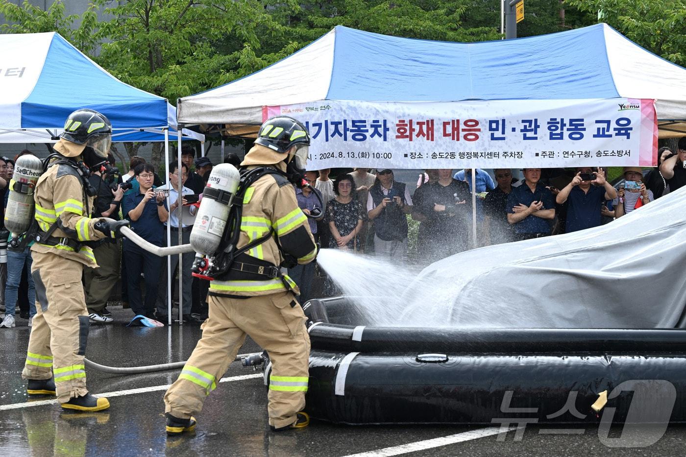 최근 잇단 화재로 이른바 &#39;전기차 공포증&#40;포비아&#41;&#39;이 확산하는 가운데 13일 인천시 연수구 송도 2동 행정복지센터 주차장에서 열린 전기자동차 화재대응 민·관 합동 교육에서 소방관들이 질식소화포와 전기차 수조탱크를 이용한 전기차 화재 진압 모의 시연을 하고 있다.&#40;중부일보 제공&#41;2020.8.13/뉴스1