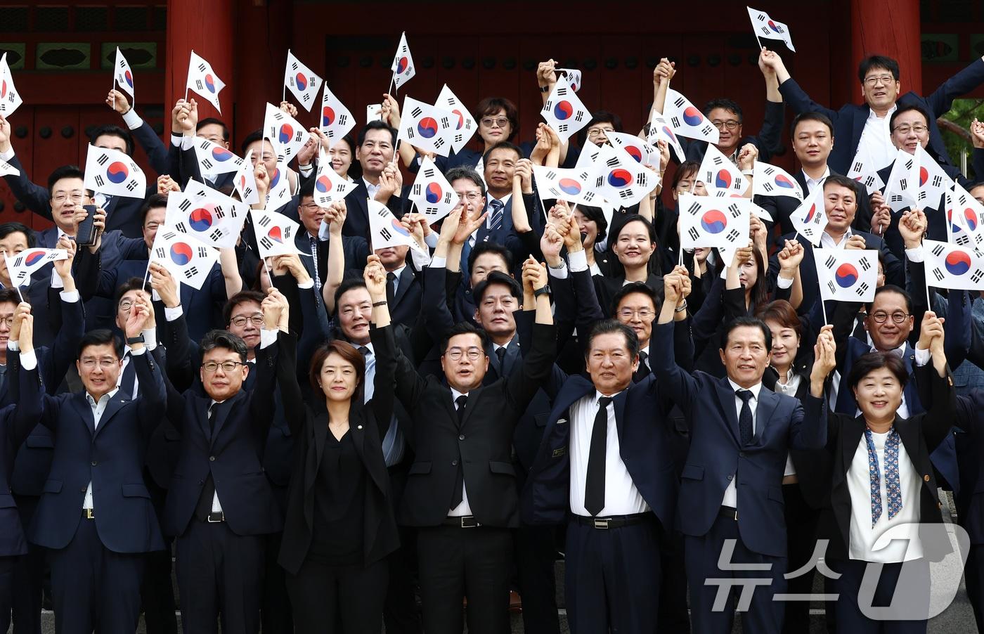 박찬대 더불어민주당 대표 직무대행 겸 원내대표를 비롯한 지도부가 제79주년 광복절인 15일 오전 서울 용산구 효창공원에서 임정요인&#40;이동녕·조성환·차리석&#41; 묘역 참배에 앞서 태극기를 들고 만세삼창을 하고 있다. 이날 민주당 등 야당은 김형석 신임 독립기념관장 임명에 반대해 정부 주최 광복절 경축식에 불참했다. 2024.8.15/뉴스1 ⓒ News1 김민지 기자