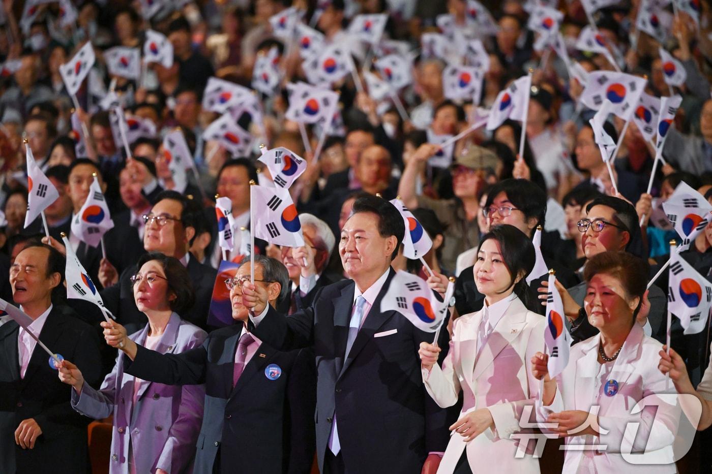 윤석열 대통령과 김건희 여사가 15일 서울 종로구 세종문화회관에서 열린 제79주년 광복절 경축식에서 태극기를 흔들고 있다. &#40;대통령실 제공&#41; 2024.8.15/뉴스1 ⓒ News1 송원영 기자