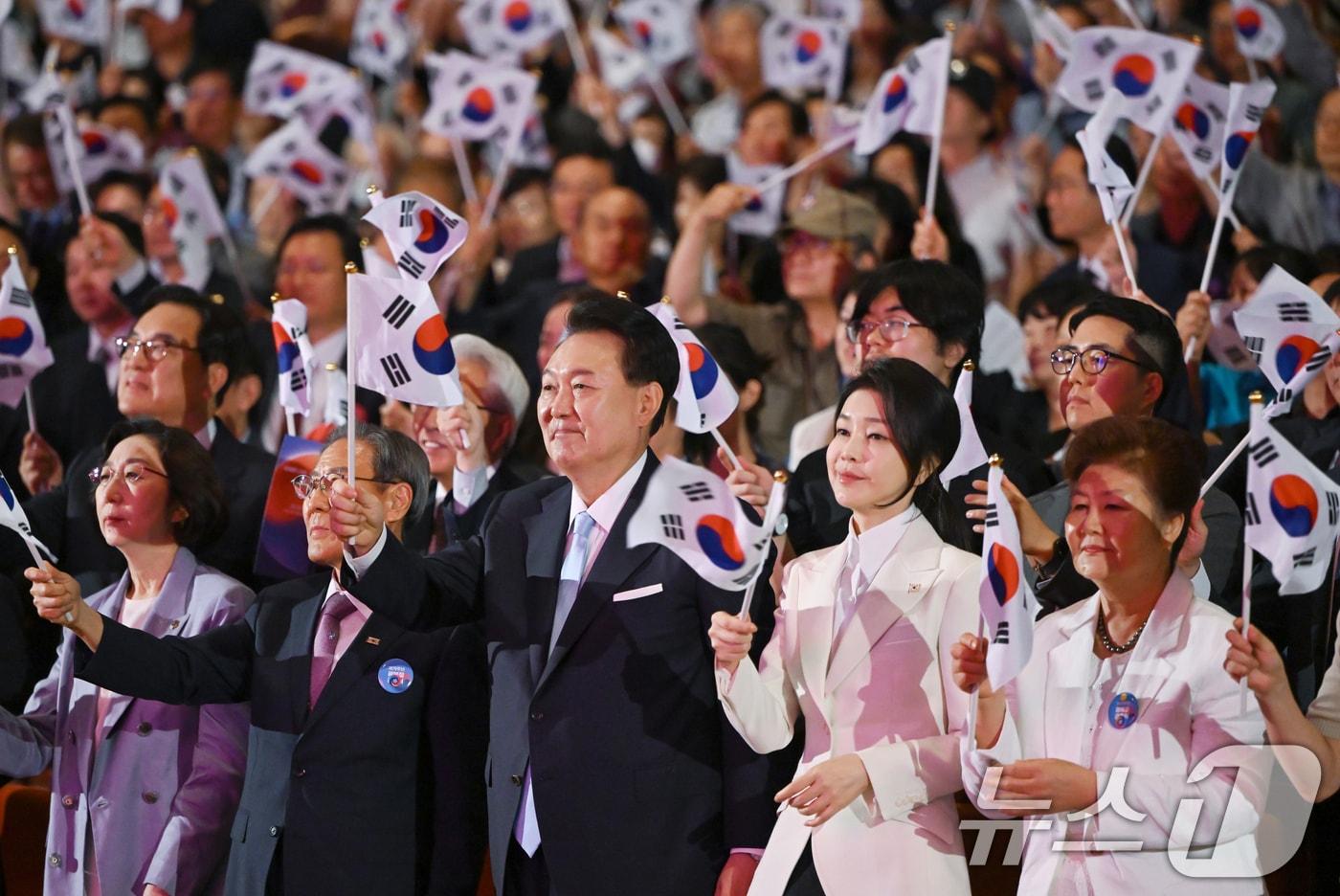 윤석열 대통령과 김건희 여사가 15일 서울 종로구 세종문화회관에서 열린 제79주년 광복절 경축식에서 태극기를 흔들고 있다. &#40;대통령실 제공&#41; 2024.8.15/뉴스1 ⓒ News1 송원영 기자