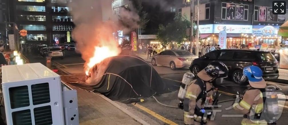 경기도의회 이상원 의원&#40;국민의힘·고양7&#41;이 지상주차장에 충전시설·전용주차구역 설치 권고 등을 담은 조례 제정을 추진한다. 사진은 16일 용인시 구갈동 한 도로에 주차된 테슬라에서 화재가 발생함에 따라 소방관들이 질식소화덮개를 활용해 열폭주를 저지하고 있다.&#40;경기도소방재난본부 제공&#41;/