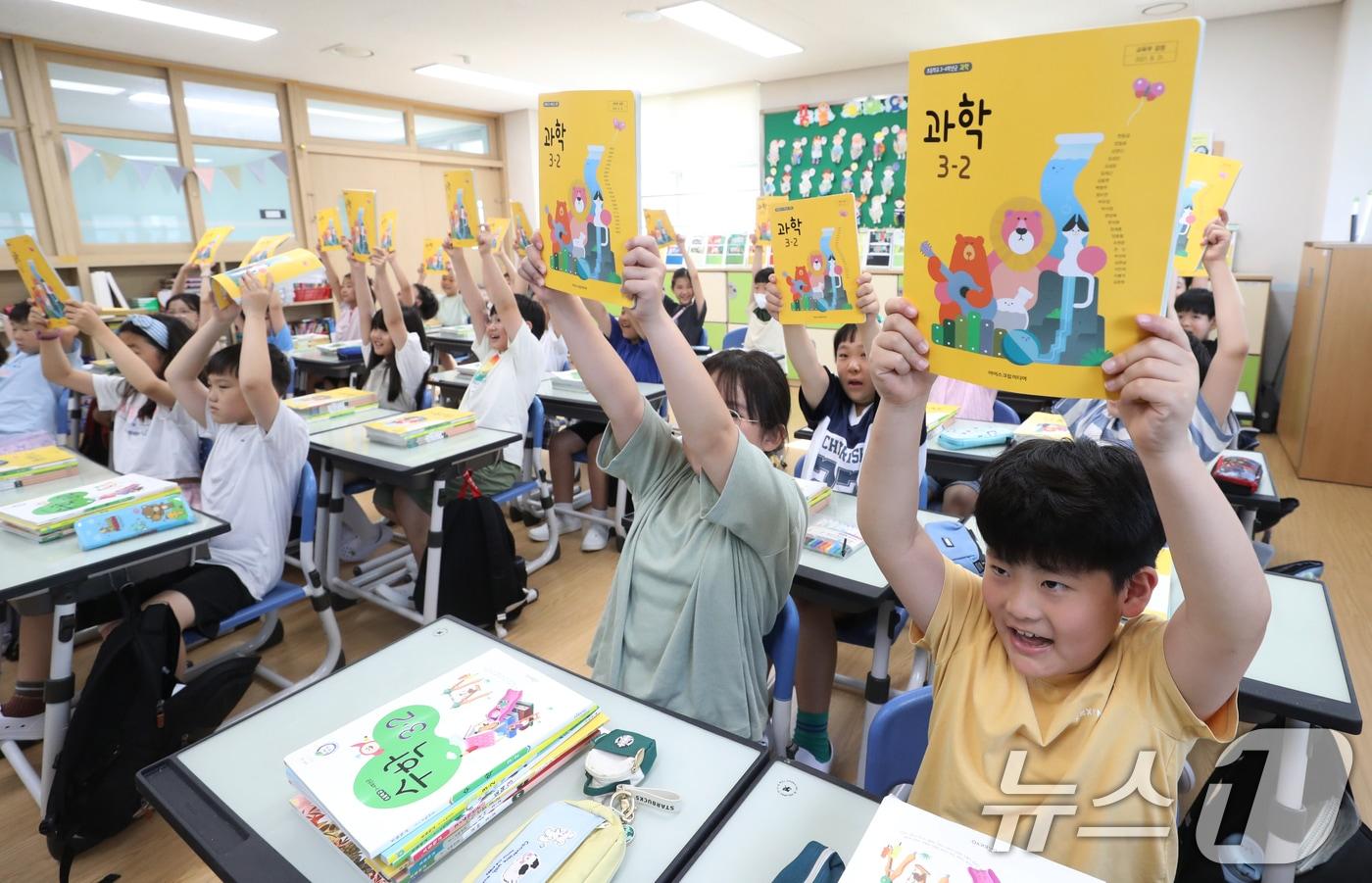 여름방학이 끝나고 개학한 19일 오전 경기 수원시 영통구 망포초등학교에서 3학년 6반 학생들이 새로 받은 2학기 교과서를 들어보이고 있다. 2024.8.19/뉴스1 ⓒ News1 김영운 기자