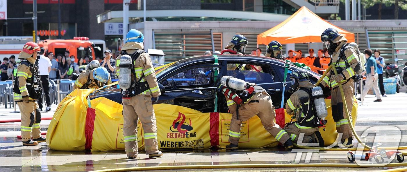 28일 서울 성동구 왕십리광장에서 열린 성동구, 성동소방서와 전기차 화재 대응 합동 훈련에서 소방관들이 불이난 전기차에 포켓식 소화 수조를 설치하고 있다.&#40;사진은 기사 내용과 무관함&#41; 2024.8.28/뉴스1 ⓒ News1 박지혜 기자