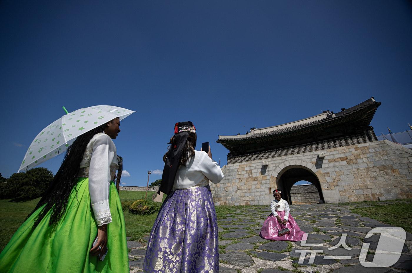 맑은 날씨를 보인 28일 오후 경기도 수원시 팔달구 세계문화유산 수원화성 창룡문을 찾은 외국인 관광객들이 파란 하늘을 배경으로 기념 촬영을 하고 있다. 2024.8.28/뉴스1 ⓒ News1 이재명 기자