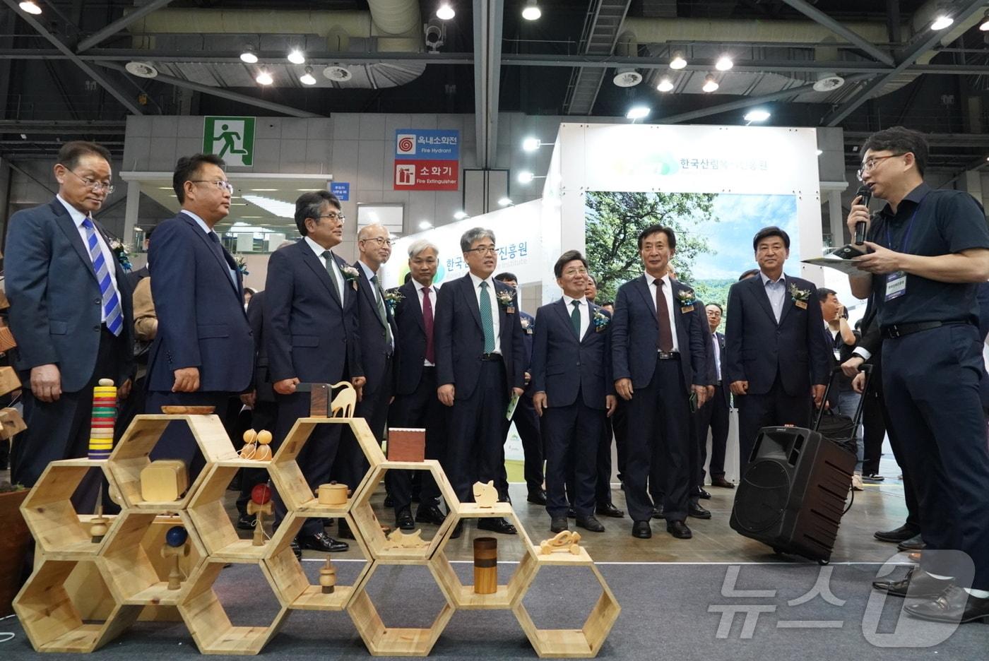 임상섭 산림청장&#40;가운데&#41;이 &#39;대한민국 목재산업 박람회&#39;에서 참석자들과 전시부스를 방문하고 있다.&#40;산림청 제공&#41;/뉴스1