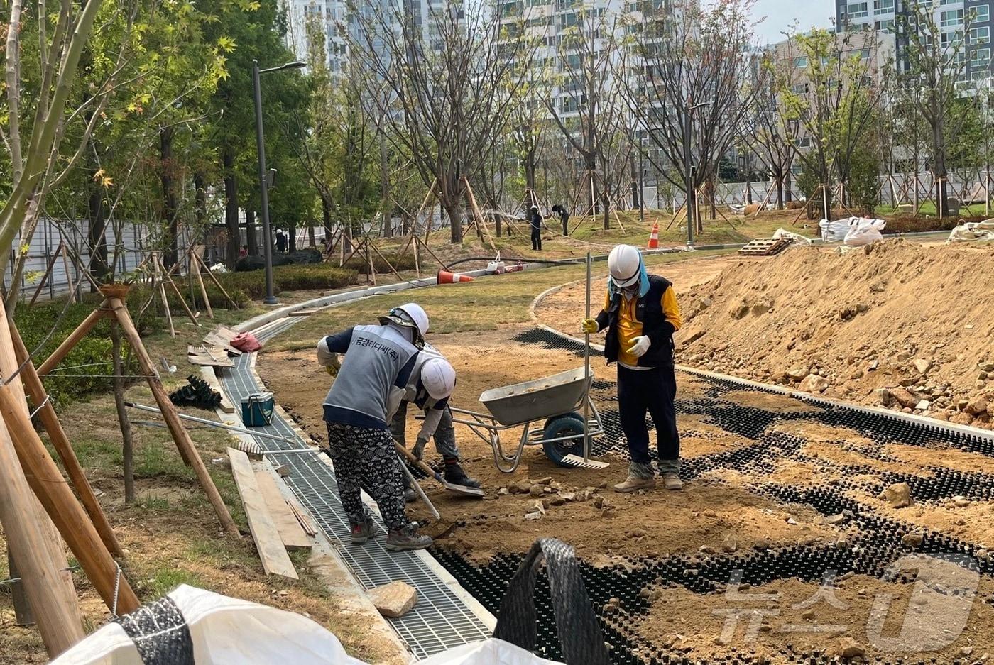 8일 오후 부산 부산진구 한 건설현장에서 근로자들이 조경 작업을 위해 땅을 골라내고 있다.2024.8.8/뉴스1 ⓒ News1 장광일기자