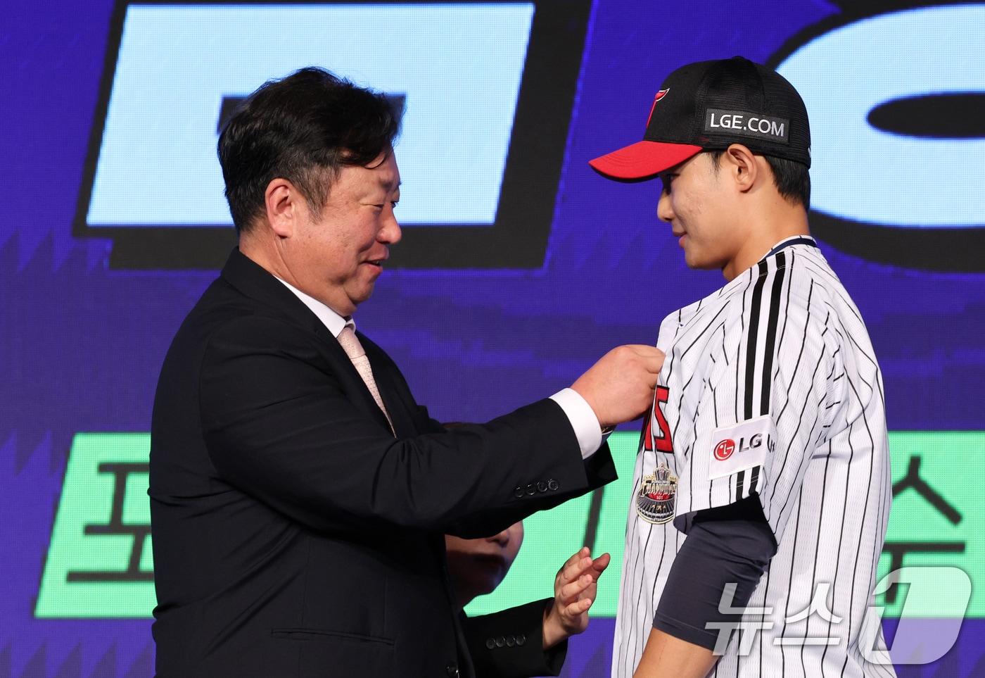 11일 오후 서울 송파구 롯데호텔 월드에서 열린 ‘2025 KBO 신인 드래프트’에서 LG 1라운드 10순위로 지명된 김영우&#40;서울고&#41;가 LG 차명석단장으로부터 유니폼을 받고 있다. 2024.9.11/뉴스1 ⓒ News1 장수영 기자