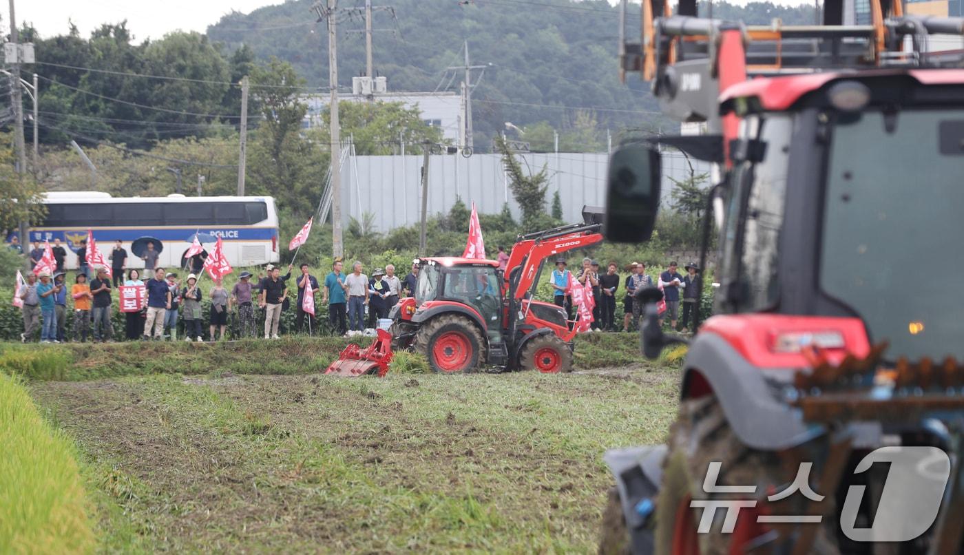 지난달 경기 안성시 미양면의 한 논에서 열린 &#39;전국농민회총연맹 경기도연맹 논 갈아엎기 투쟁&#39;에서 농민들이 쌀값 보장과 쌀 수입 반대를 촉구하며 트랙터를 이용해 논을 갈아엎고 있다. ⓒ News1 김영운 기자