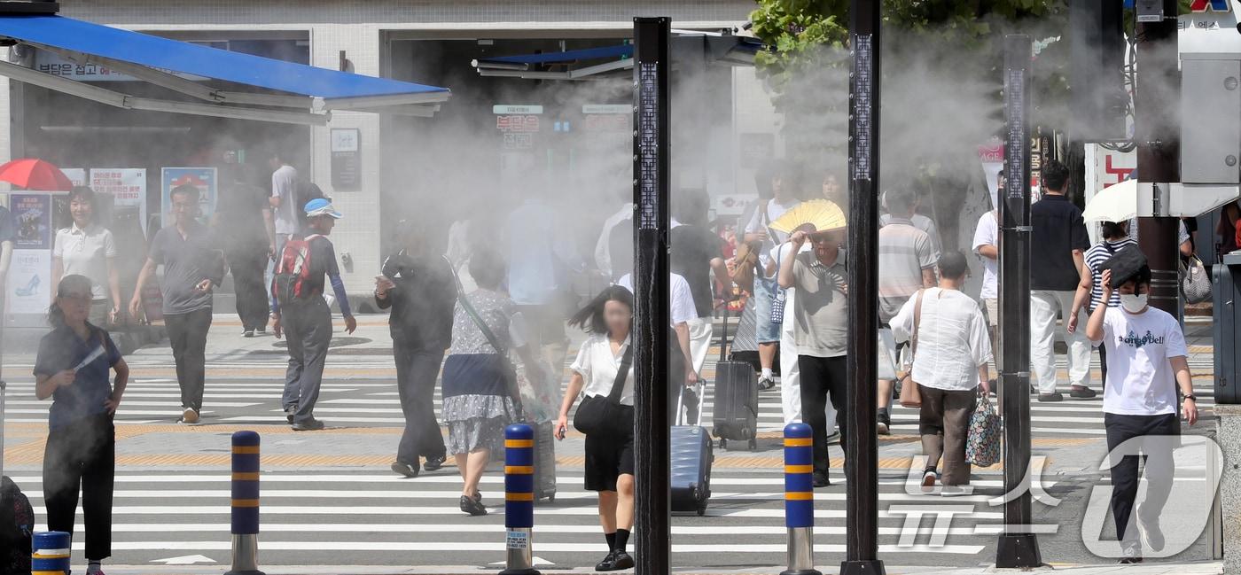 추석 연휴를 하루 앞둔 13일 부산에 폭염경보가 발효된 가운데 부산역 앞을 지나는 귀성객 등 시민들 사이로 쿨링포그가 작동되고 있다. 2024.9.13/뉴스1 ⓒ News1 윤일지 기자