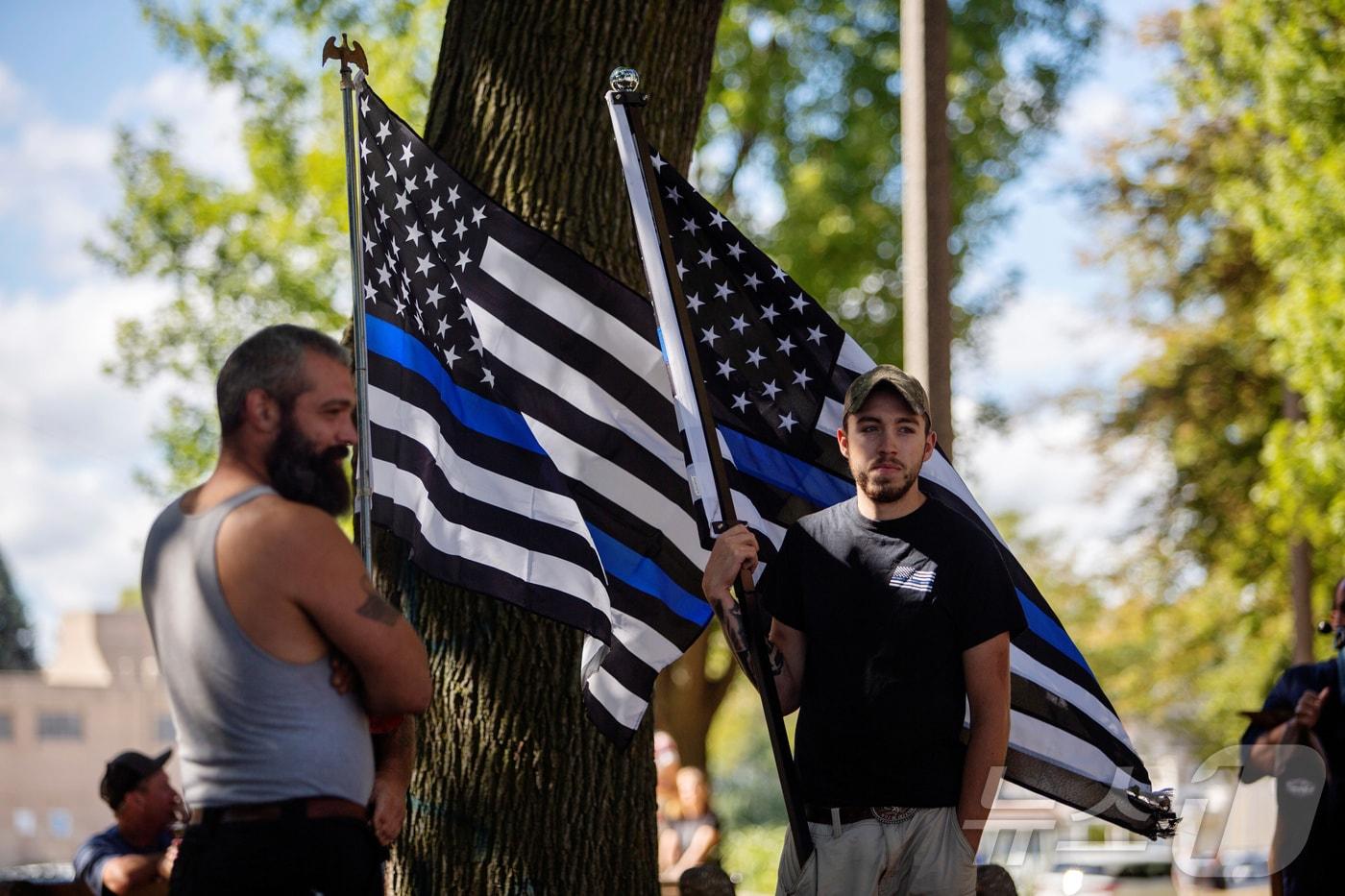 흑인 남성 제이콥 블레이크가 경찰이 쏜 총에 맞아 사망에 이르자 &#39;경찰 생명도 중요하다&#40;Blue Lives Matter&#41;&#39;운동 지지자들이 미국 위스콘신주 케노샤 시빅센터 공원에서 &#39;푸른색 얇은 선&#39; 깃발을 들고 나와 시위하고 있다. 2020.08.30 ⓒ 로이터=뉴스1 ⓒ News1 정지윤 기자