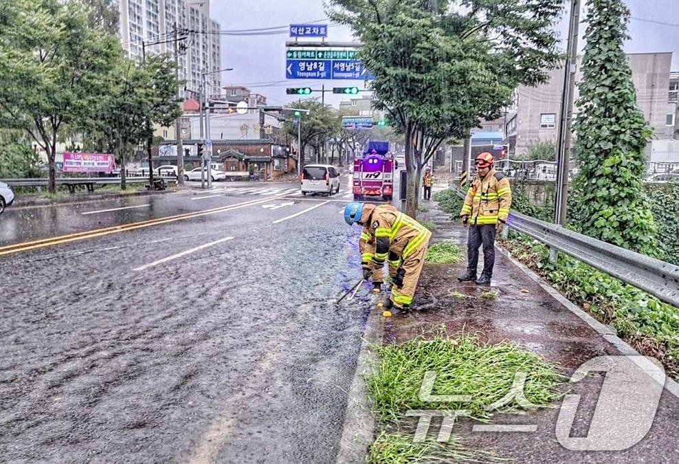 호우경보가 내려진 21일 울산 울주군 온산읍 덕산교차로에서 빗물이 역류해 소방대원이 안전 조치를 하고 있다. &#40;울산소방본부 제공&#41; 2024.9.21/뉴스1 ⓒ News1 조민주 기자